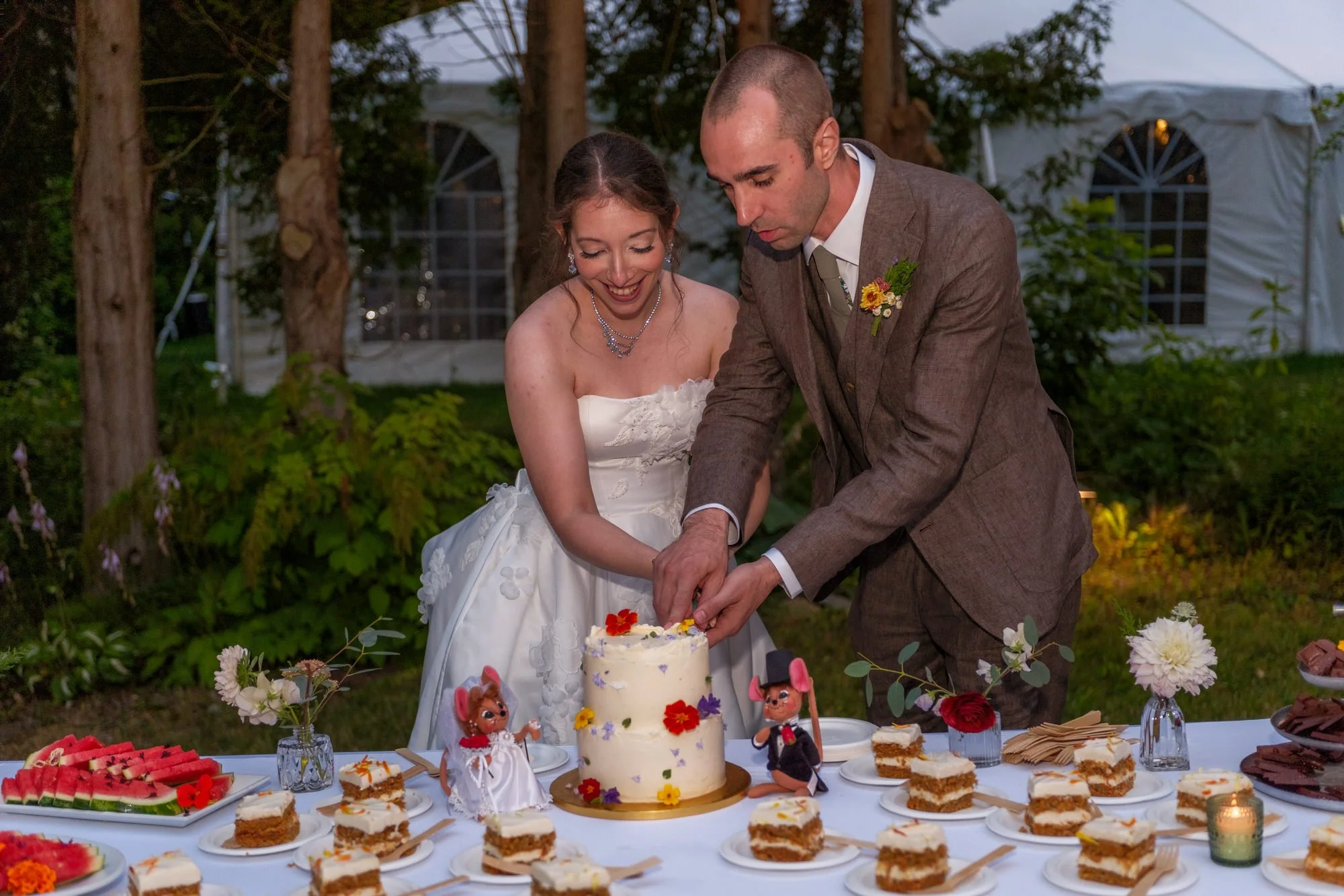 Bride and groom cutting their wedding cake outdoors