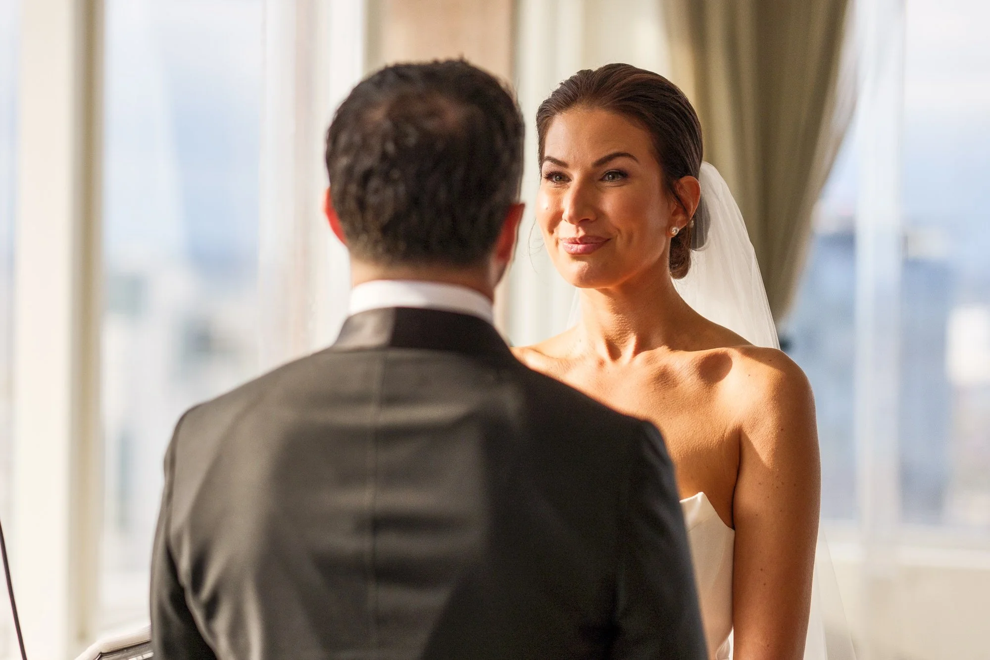 Intimate close-up of bride gazing at groom during wedding vows at the UMass Club Boston with soft window light