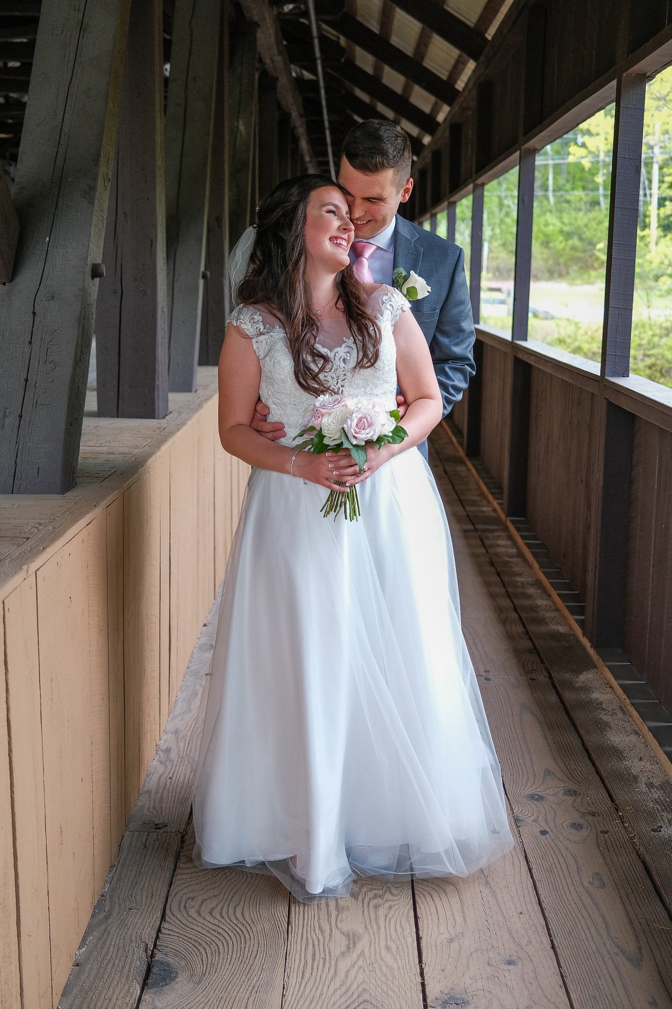 Bride and Groom share a tender moment at the Honeymoon Bridge in Jackson, NH.