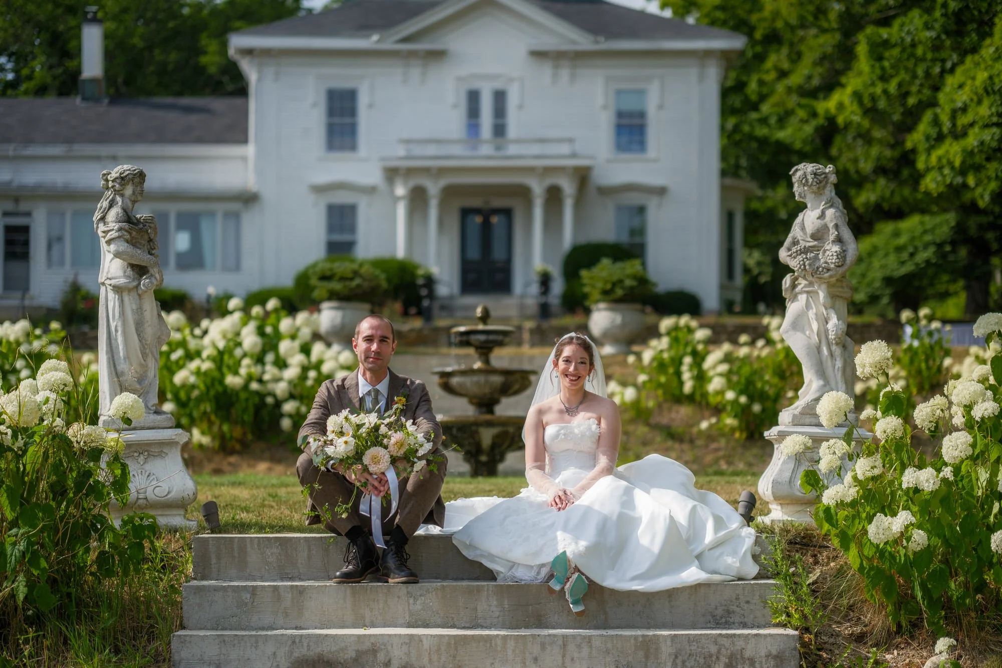 Bride and groom sitting on opposite sides of garden steps