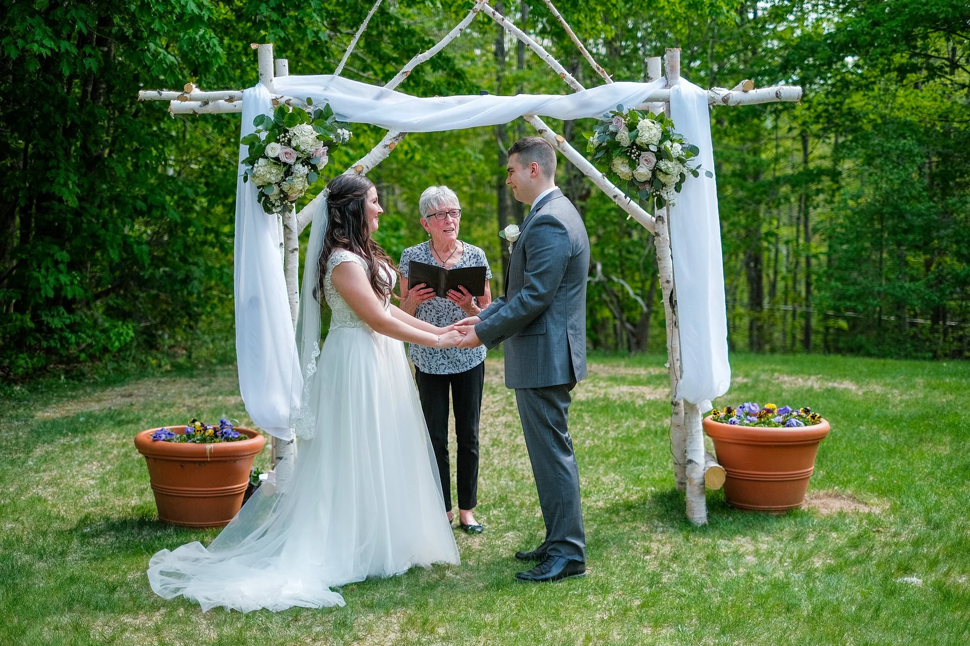 Gride and Groom exchanging vows during their elopement ceremony at The Christmas Farm Inn mid summer in Jackson, NH