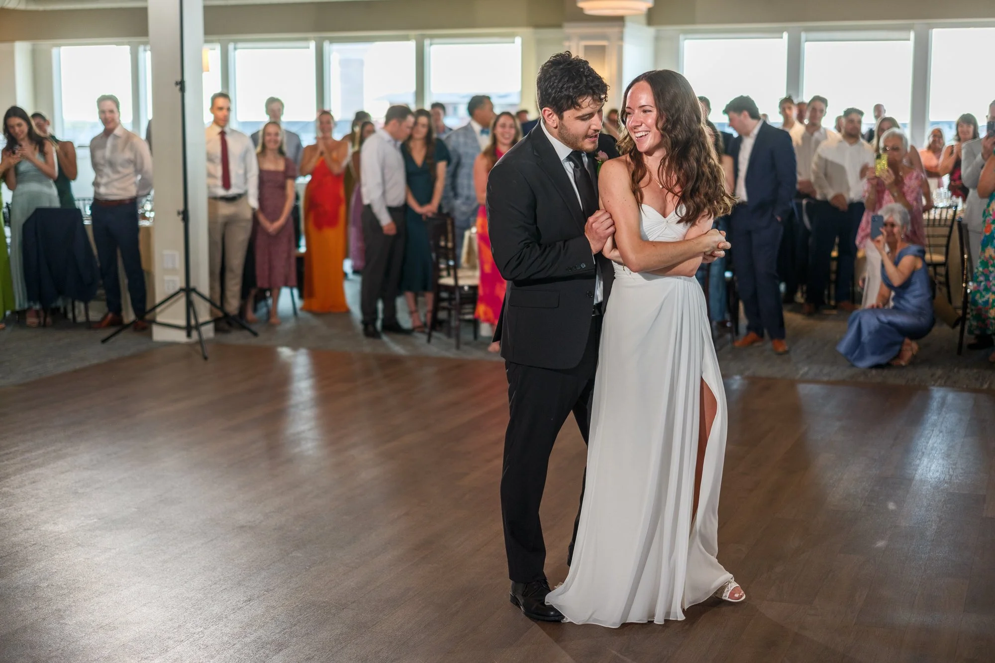 Bride and groom dancing together as guests watch at Blue Ocean Event Center in Salisbury, MA.