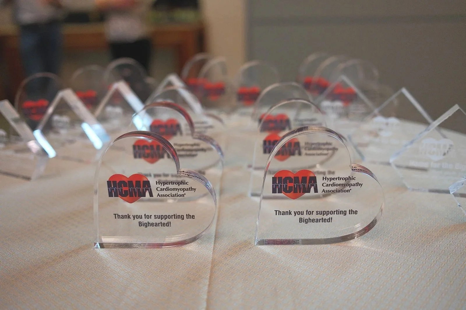 Heart-shaped acrylic HCMA sponsor award trophies displayed on a table reading Thank You for Supporting the Bighearted