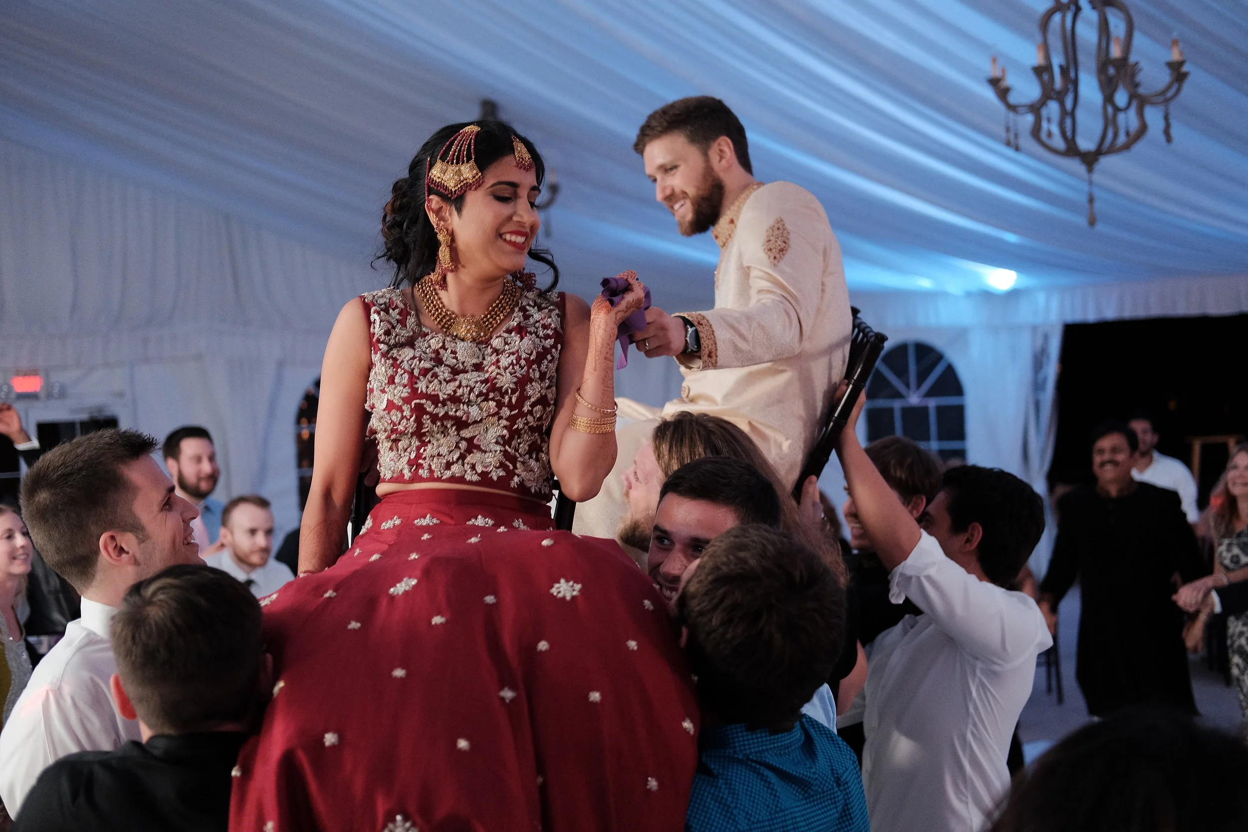 south-asian-wedding-couple-lifted-on-chairs-celebration-nh.jpg
