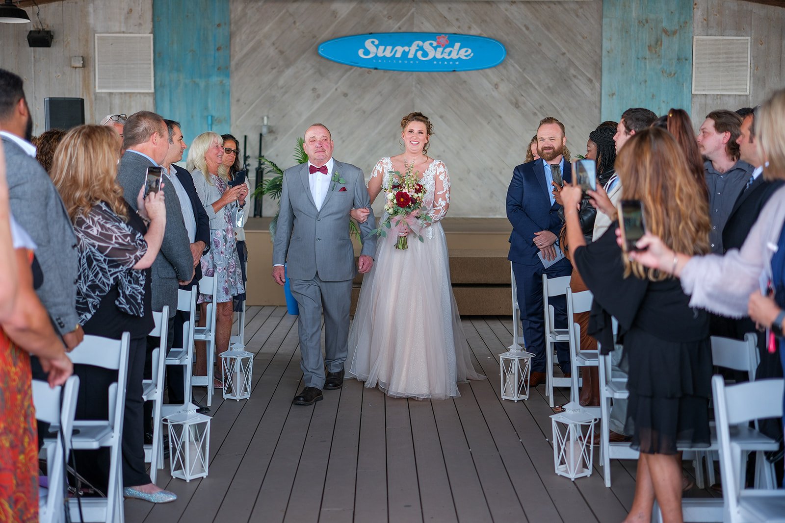 Bride walking down the aisle at Blue Ocean Event Center in Salisbury Beach, MA with guests standing on both sides