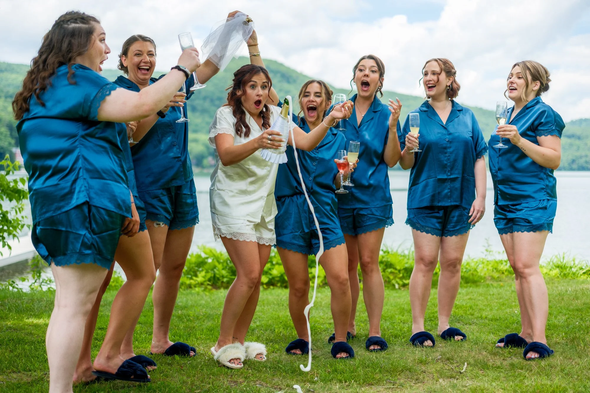 Bridesmaids celebrate with the bride during lakeside wedding prep at Lake Morey Resort in Fairlee, Vermont