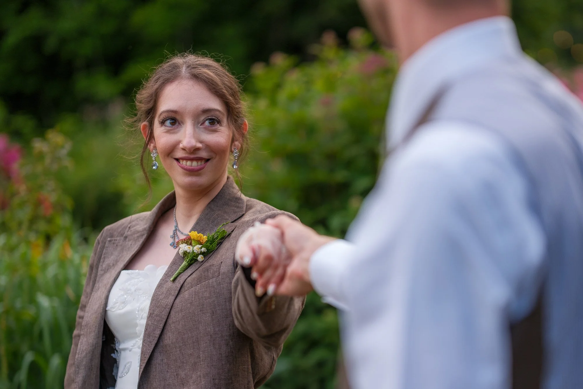 Bride laughing and pointing during a candid garden portrait