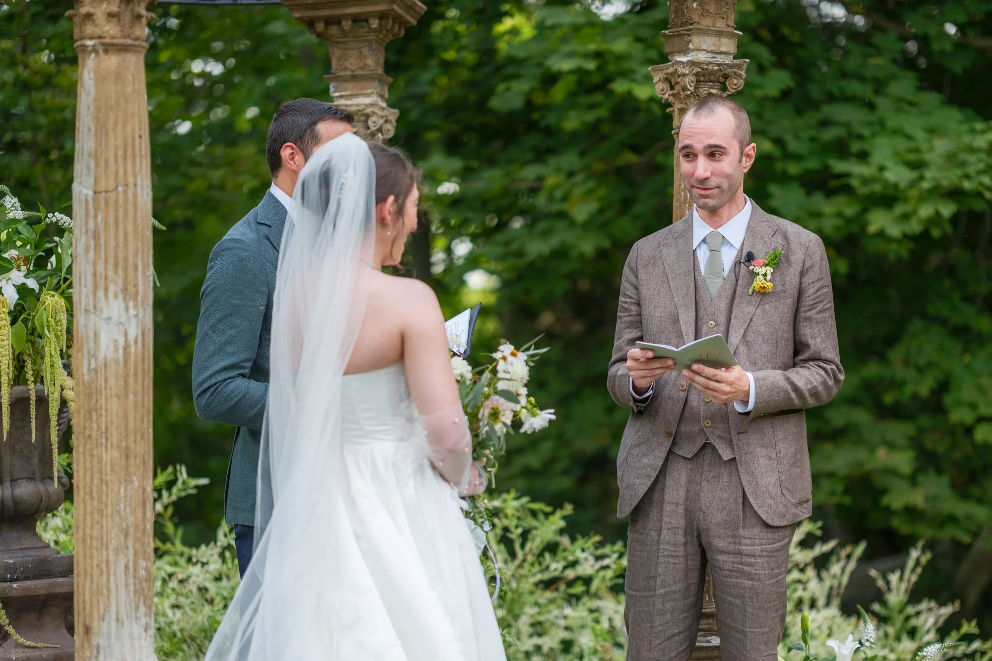 Groom reading vows to the bride during their garden ceremony