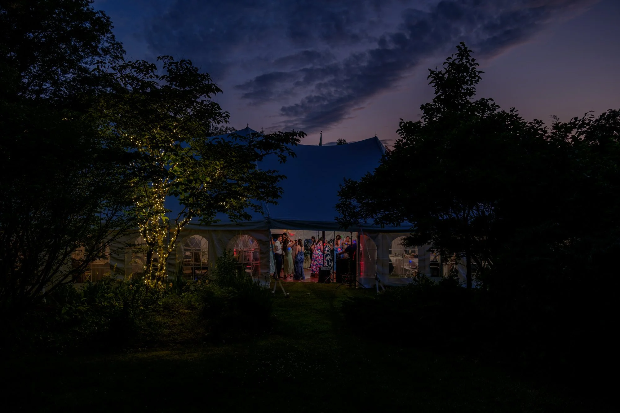 Evening wedding tent glowing by Lake Morey Resort in Fairlee, Vermont