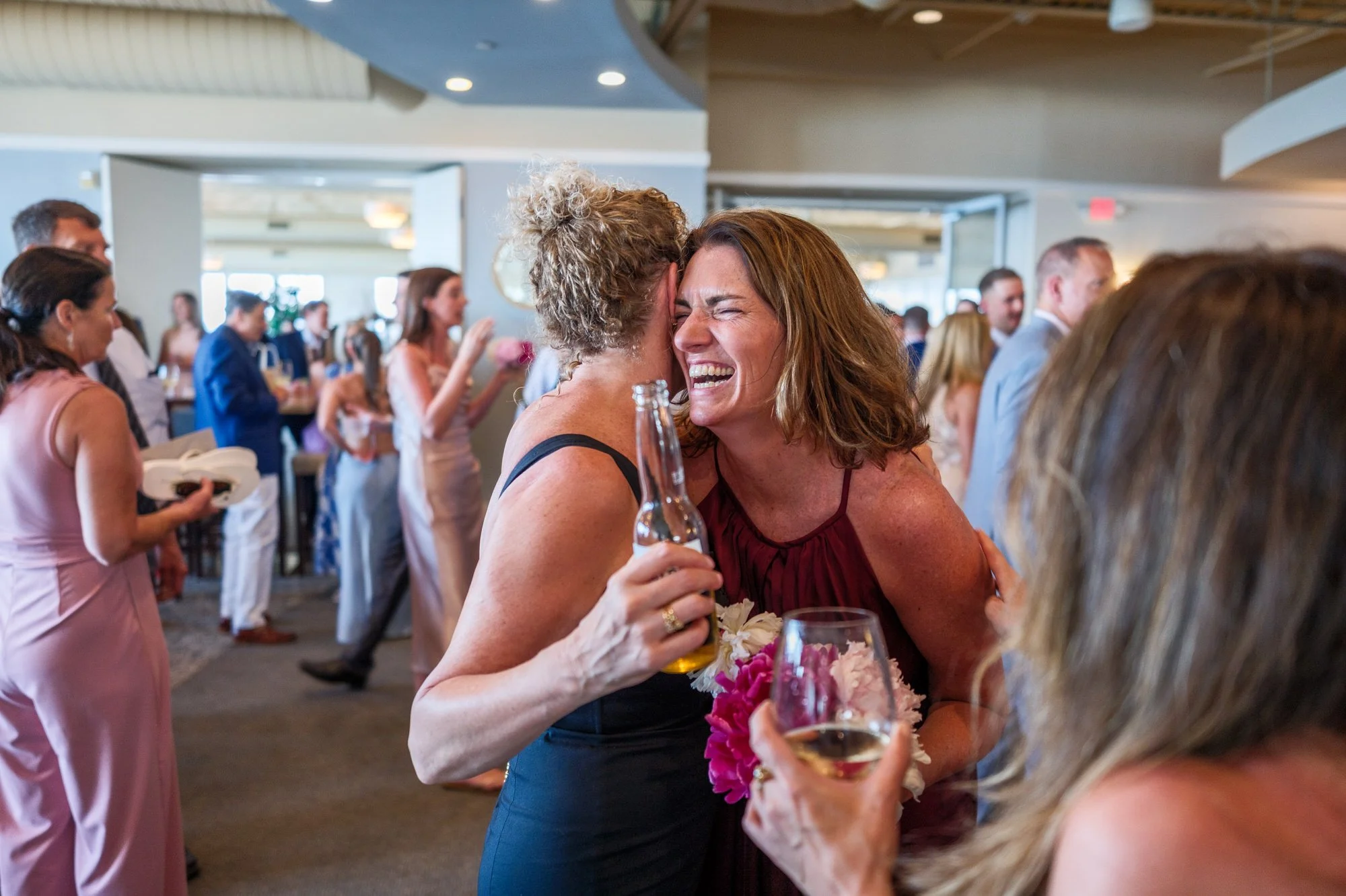 Wedding guests laughing during cocktail hour at Blue Ocean Event Center in Salisbury, MA.