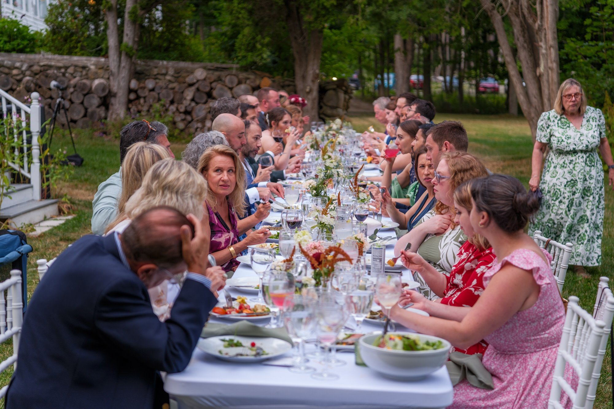 Long outdoor wedding dinner table filled with guests