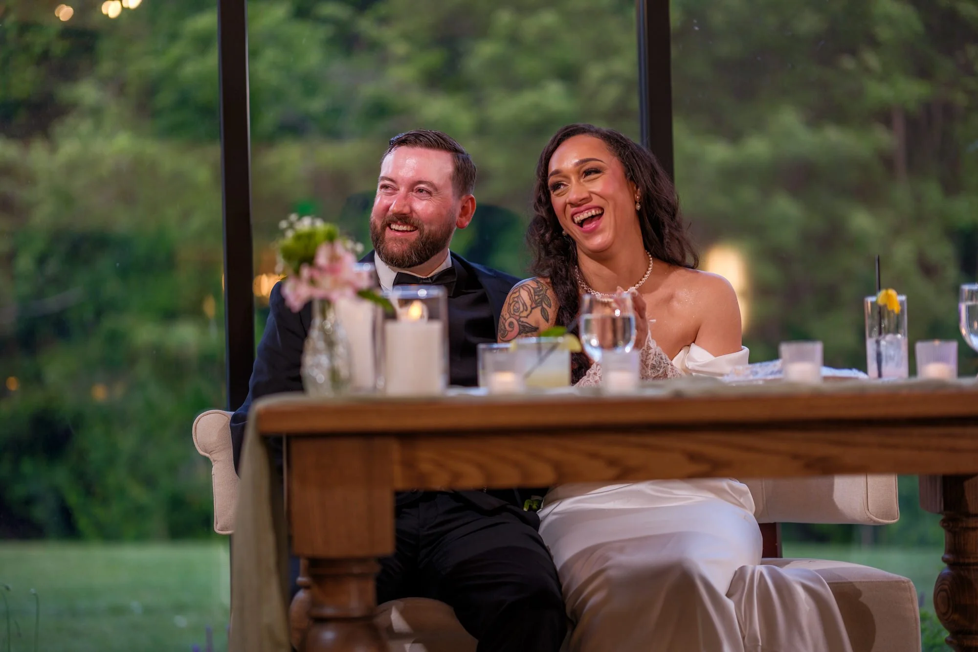 Bride and groom laughing during reception speeches at Hyla Brook Estate