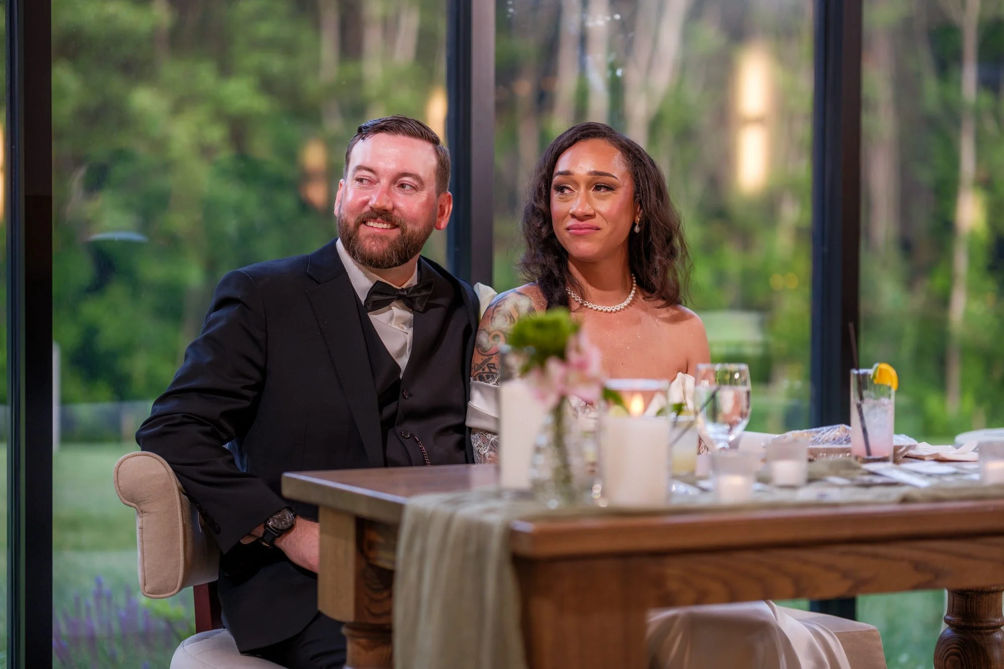 Bride and groom listening to reception speeches at Hyla Brook Estate