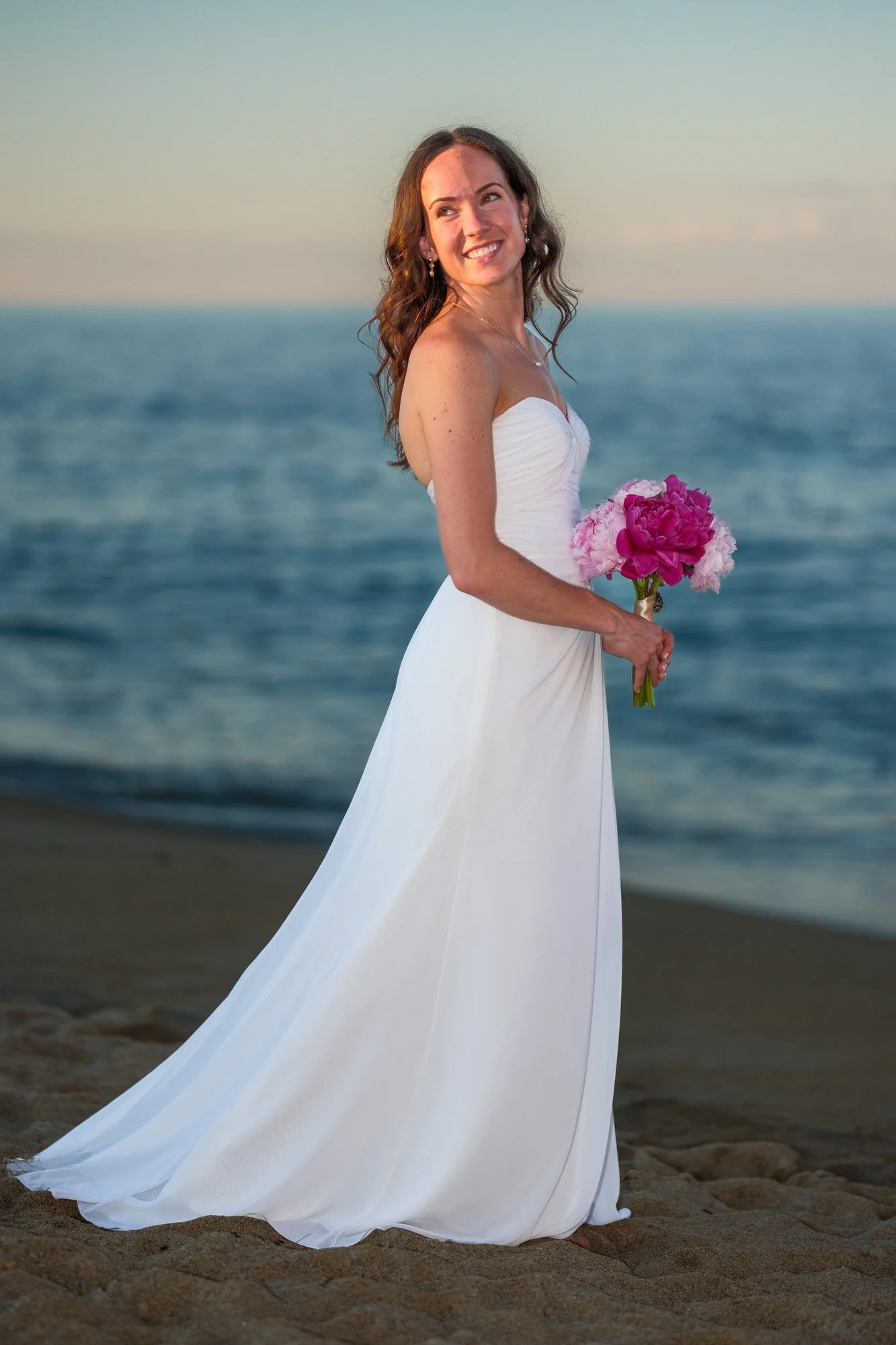 Bride holding a pink bouquet for a beach portrait near Blue Ocean Event Center in Salisbury, MA.