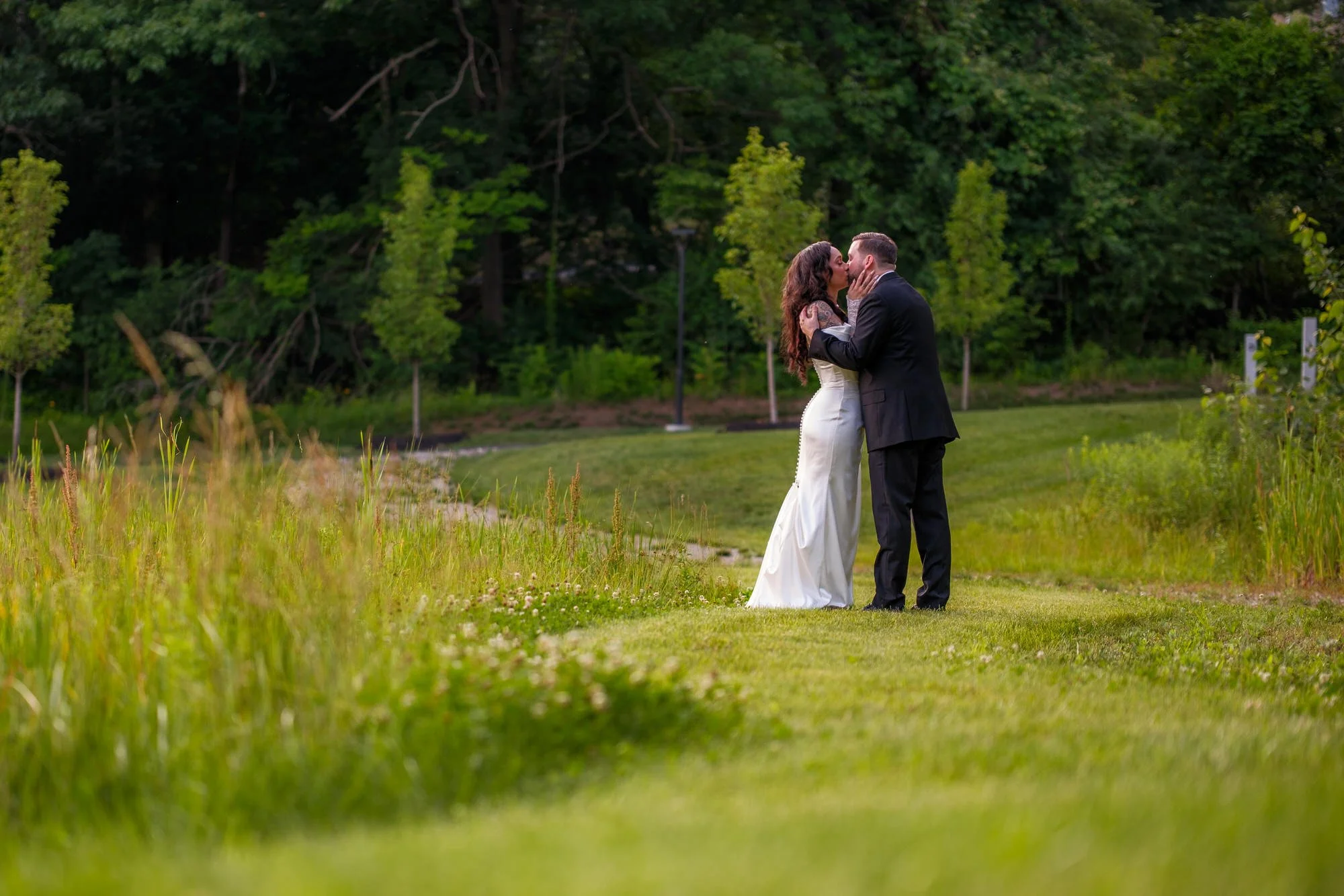 Newlyweds kissing in the meadow at Hyla Brook Estate