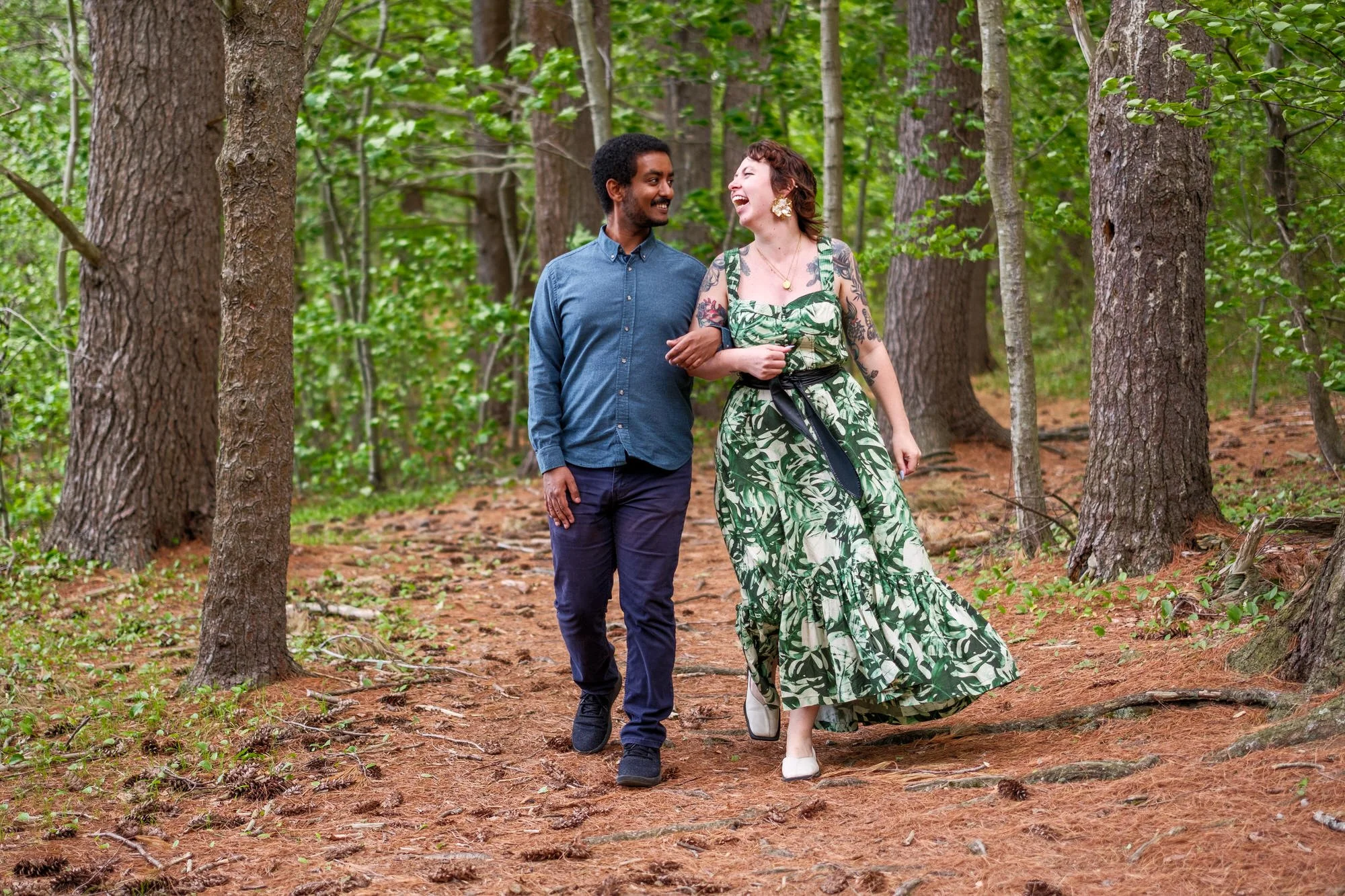 Newly engaged couple laughing while walking through Middlesex Fells Reservation