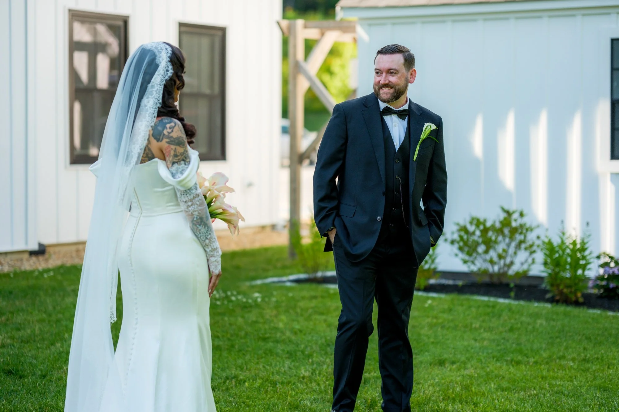 Bride and groom smiling during first look outside Hyla Brook Estate