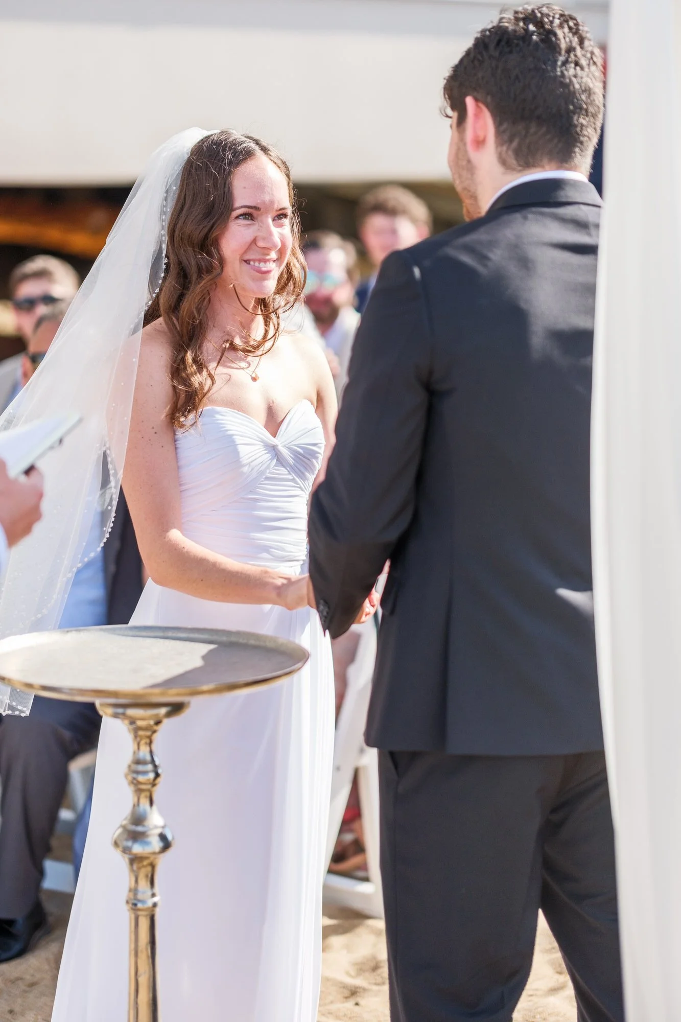 Bride smiling while reading vows during a beach wedding ceremony at Blue Ocean Event Center.