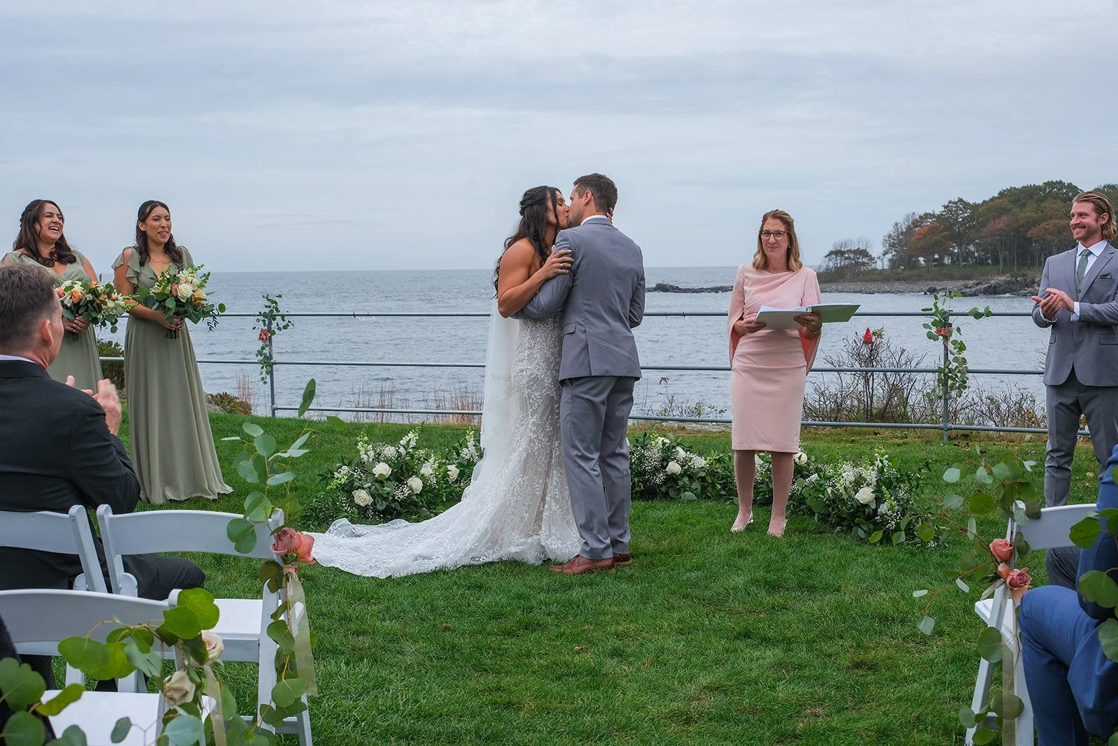 Bride and groom first kiss during outdoor ceremony at Stage Neck Inn York Maine with Atlantic Ocean backdrop