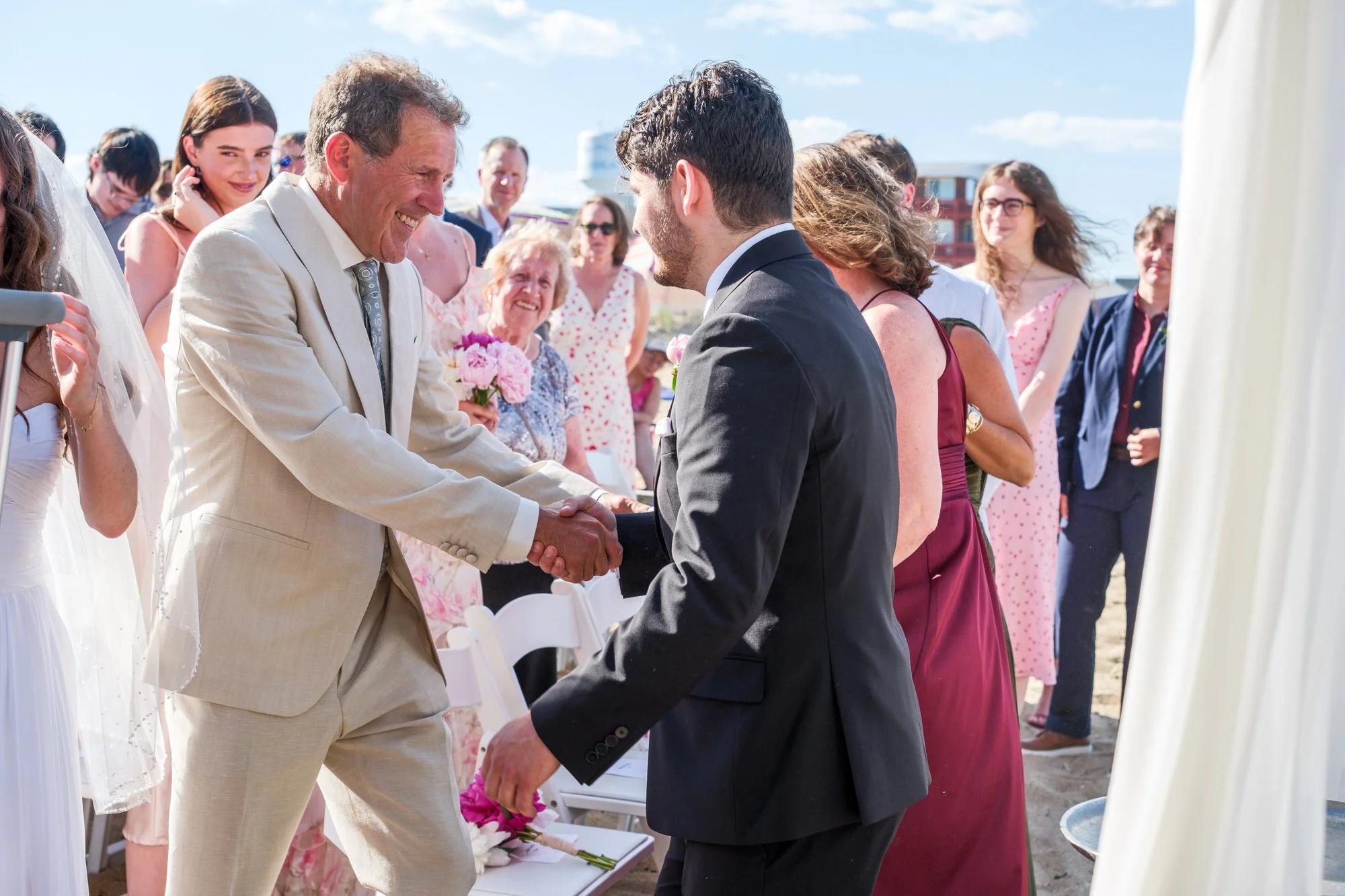 Family member greeting the groom during an oceanfront wedding ceremony in Salisbury, MA.