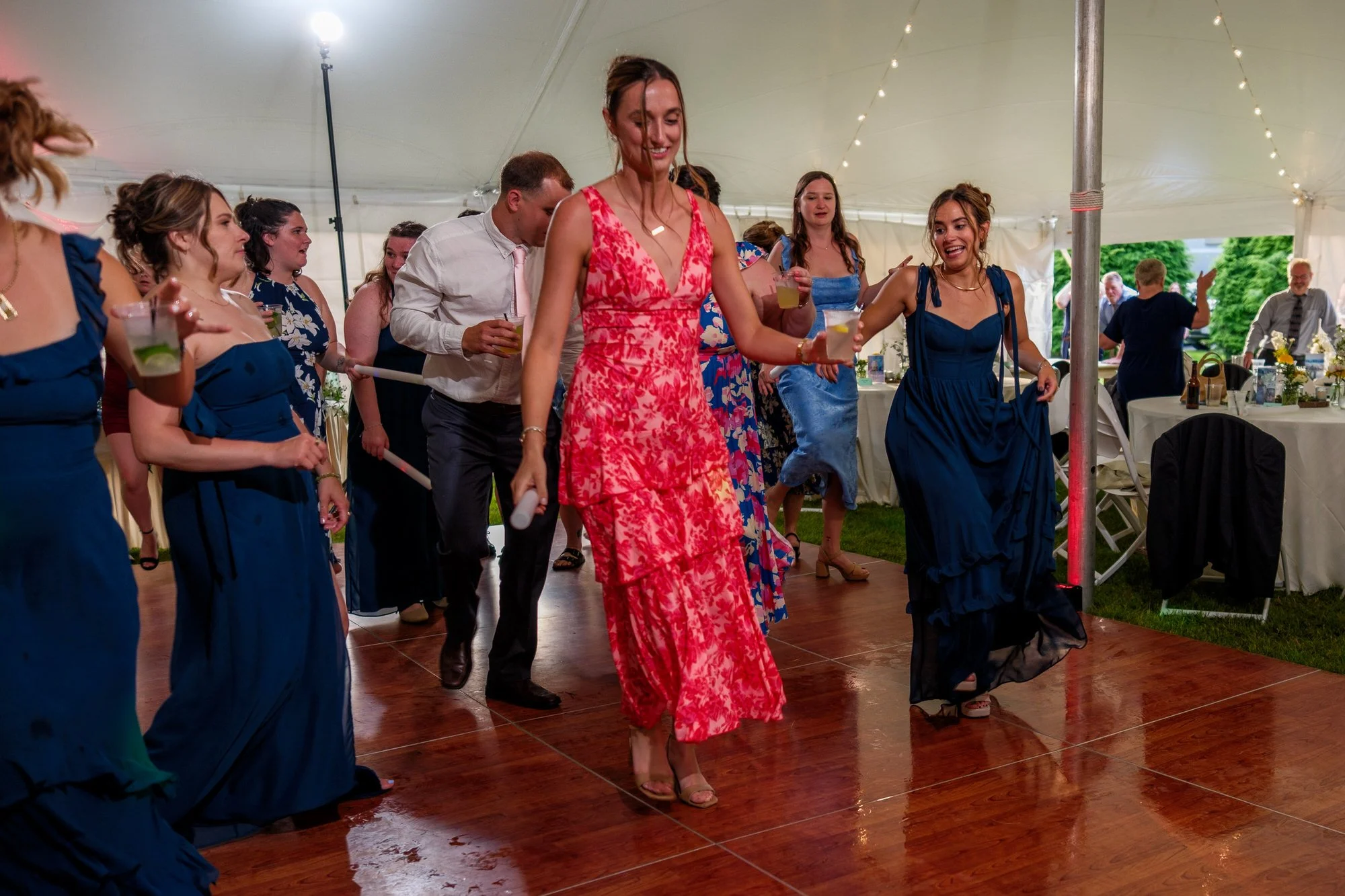 Reception guests dance beneath tent lights at Lake Morey Resort in Fairlee