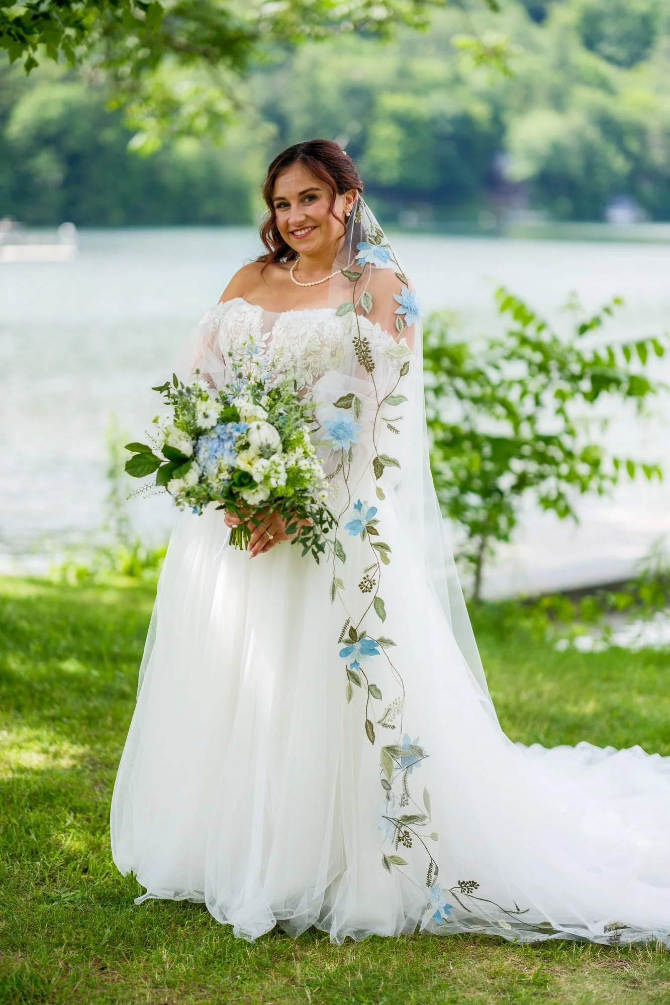Bride holding bouquet by the water at Lake Morey Resort wedding venue in Vermont