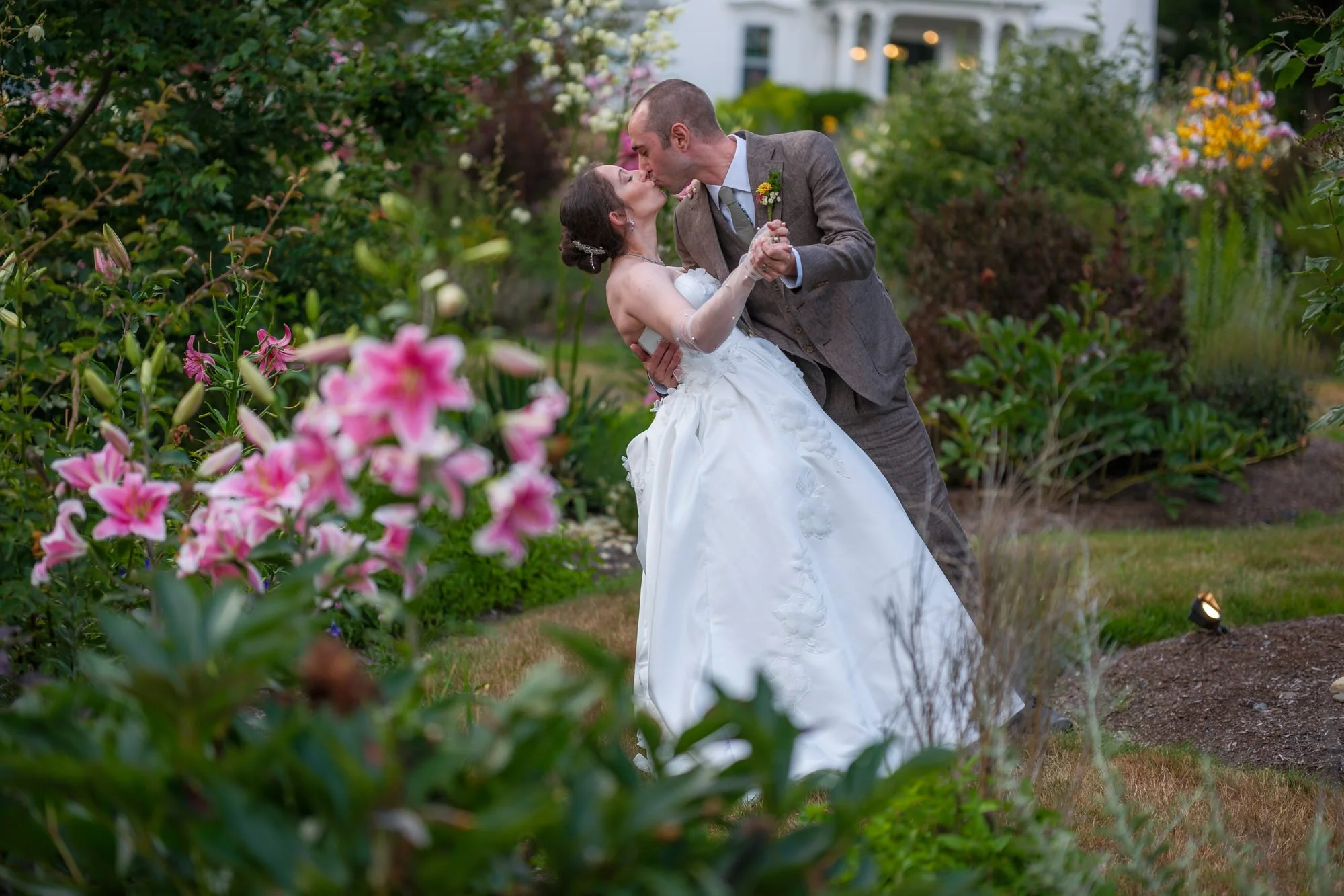 Bride and groom kissing among flowers in the garden