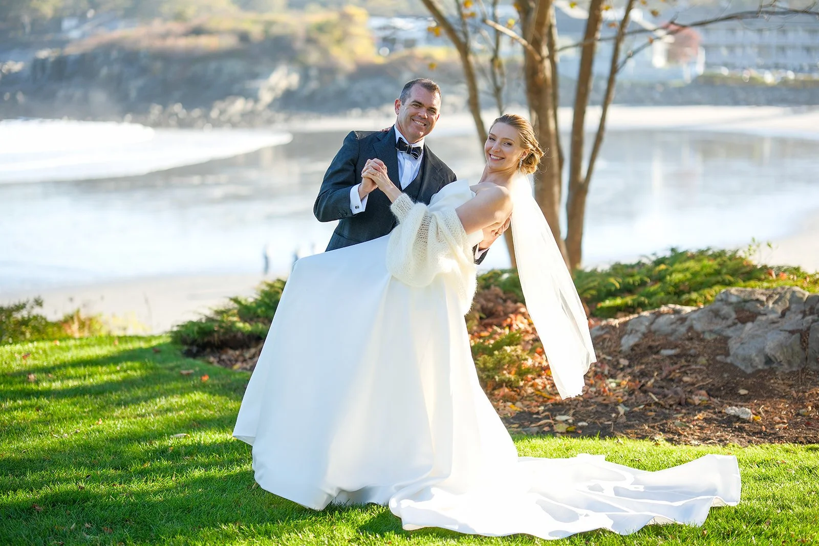 Bride and groom dancing and laughing on oceanside lawn at York Maine fall wedding