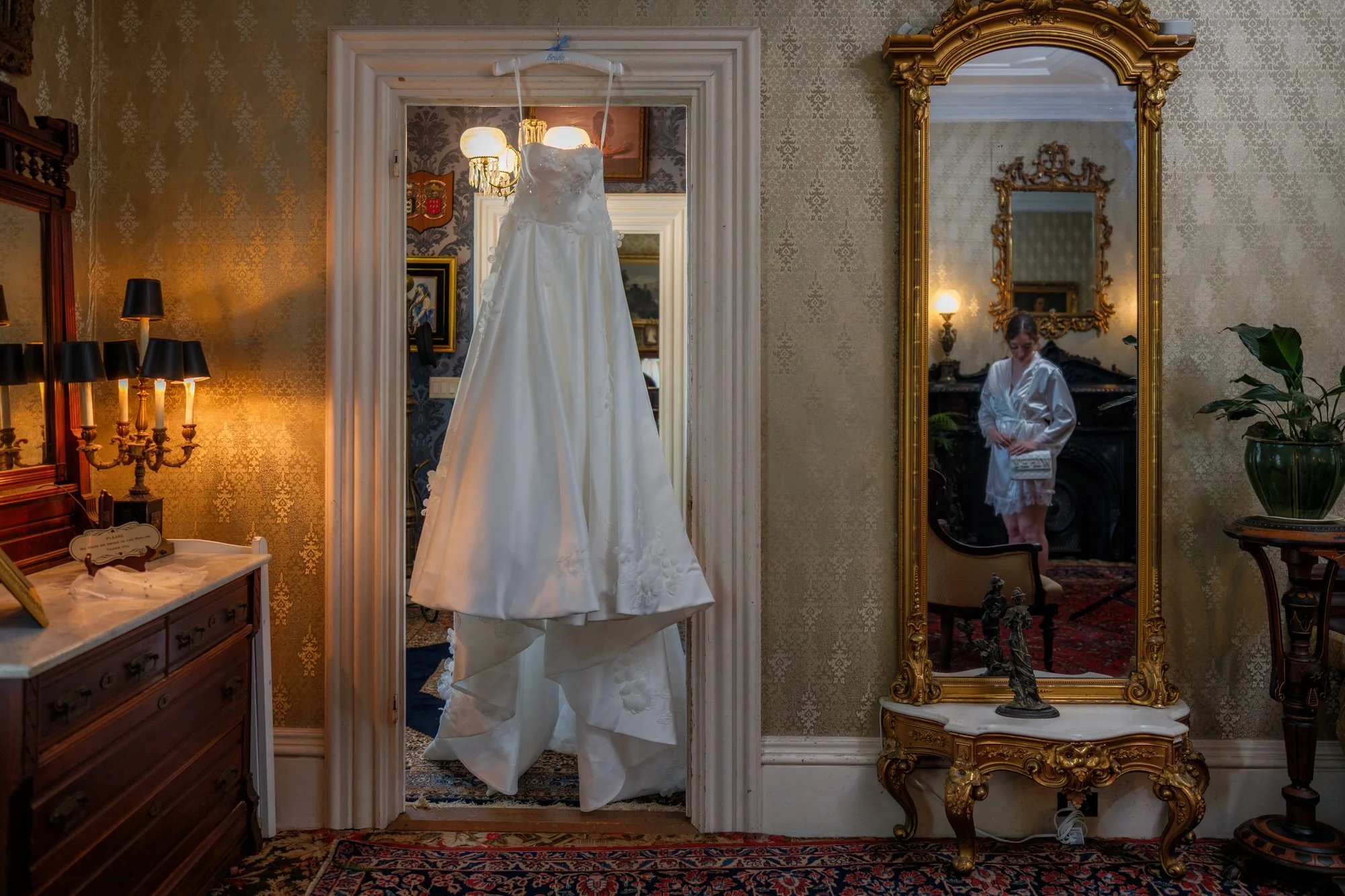 Wedding dress hanging in an elegant Belvedere House bedroom