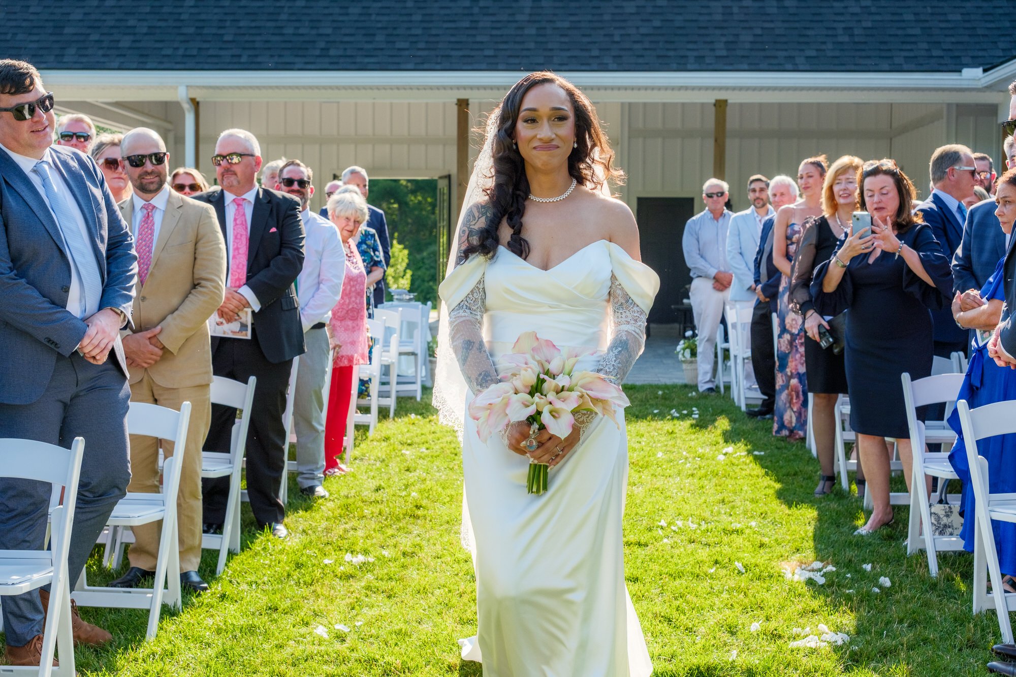 Bride walking through seated guests during Hyla Brook Estate wedding ceremony