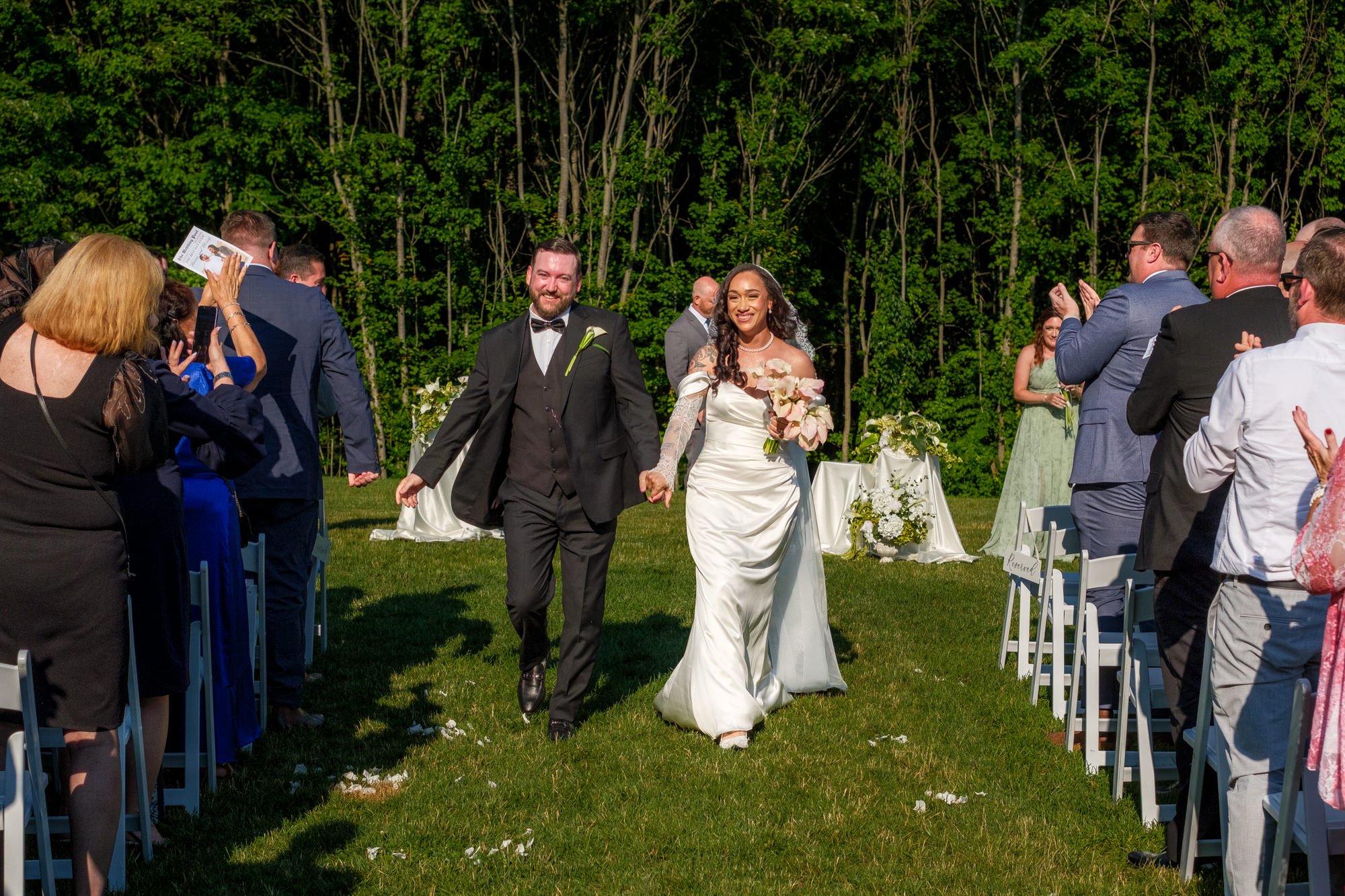 Newlyweds walking back down the aisle after Hyla Brook Estate wedding ceremony