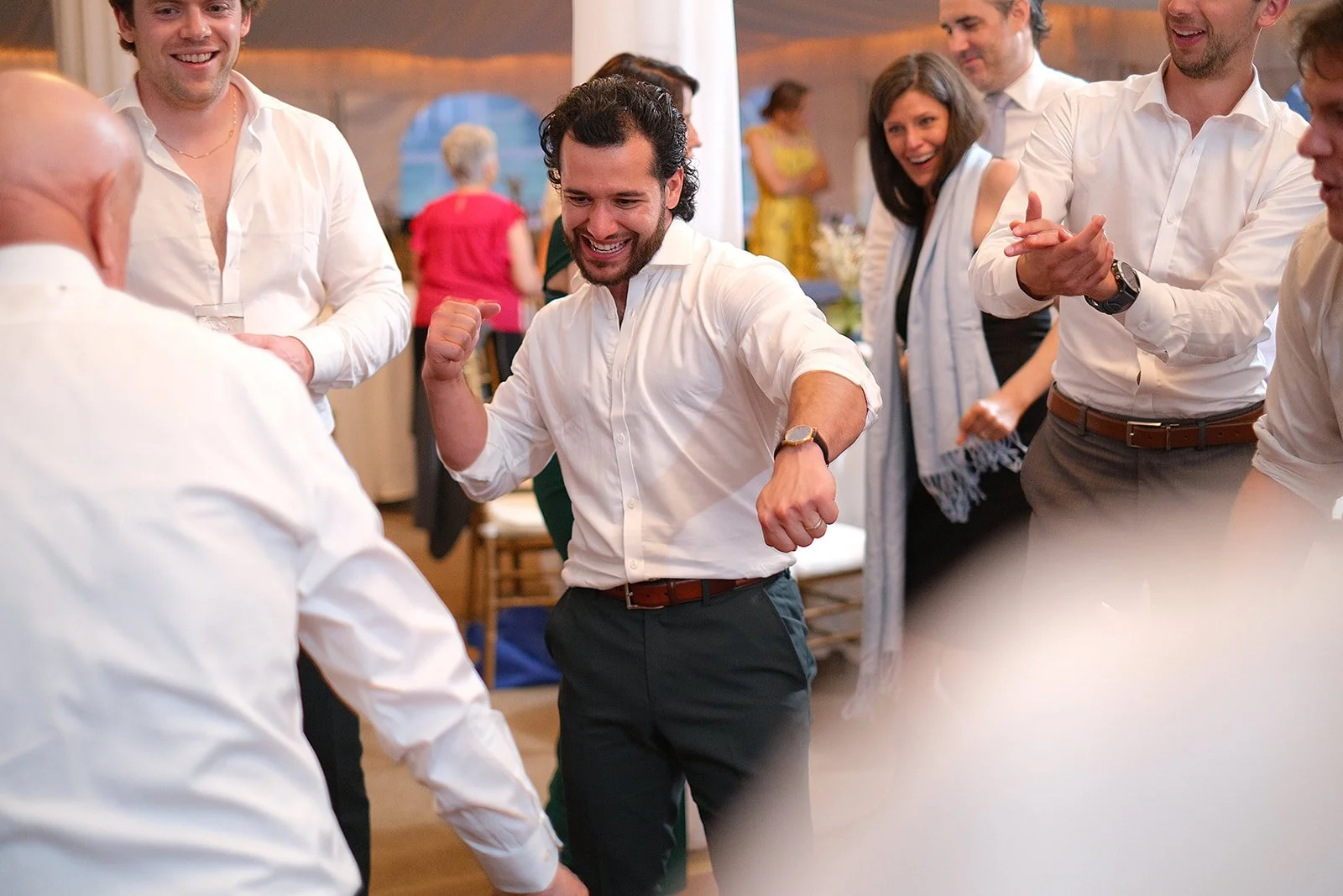 Group of people celebrating and dancing at a social event or party indoors.