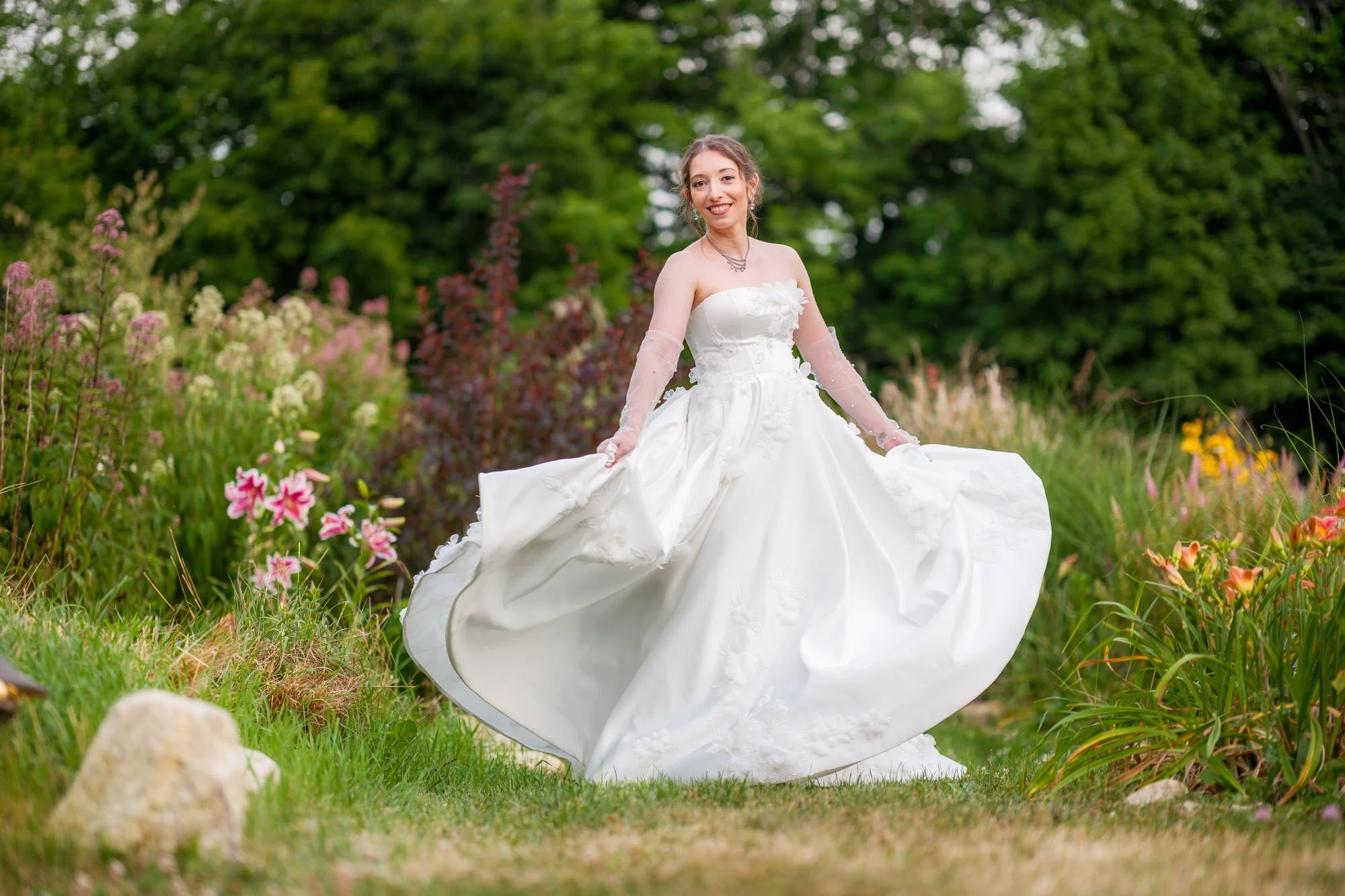 Bride twirling her wedding dress in the flower garden