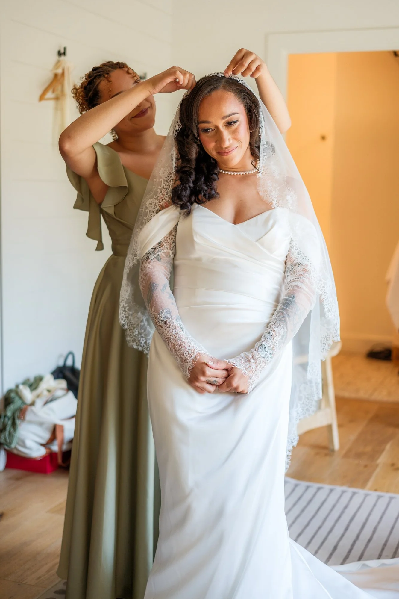 Bride putting on vale before her wedding at Hyla Brook Estate