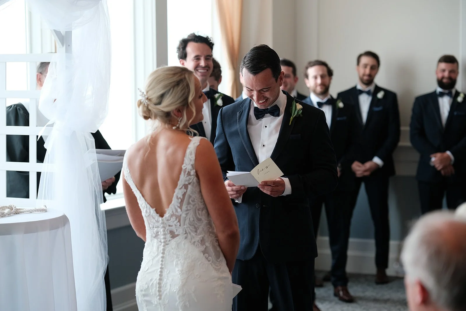 Groom smiling while reading personal vows at Blue Ocean Event Center wedding ceremony in Salisbury Beach MA