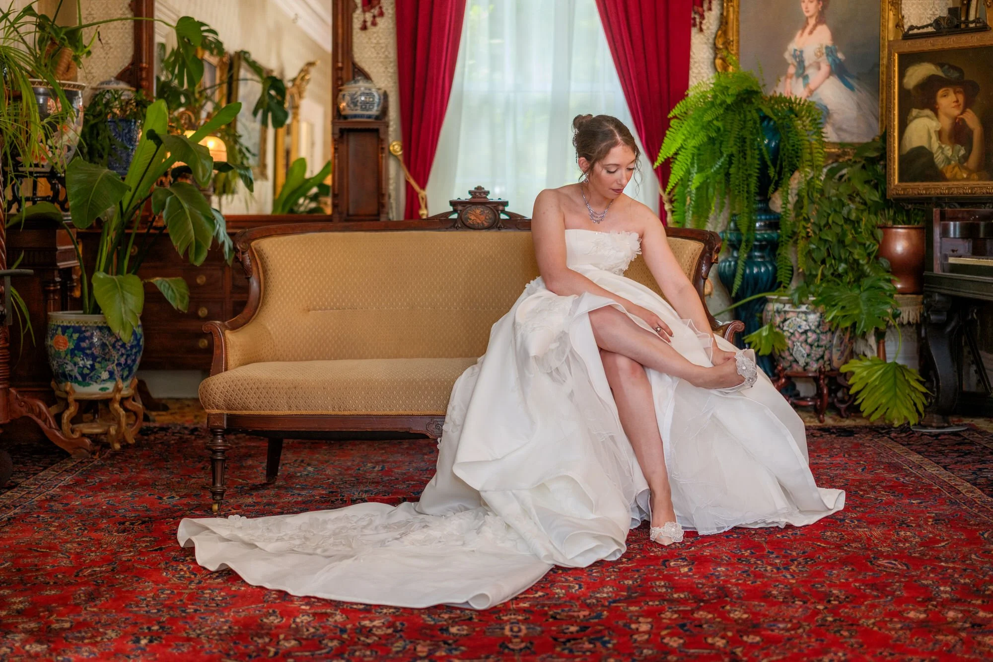 Bride putting on her wedding shoes in a historic mansion parlor
