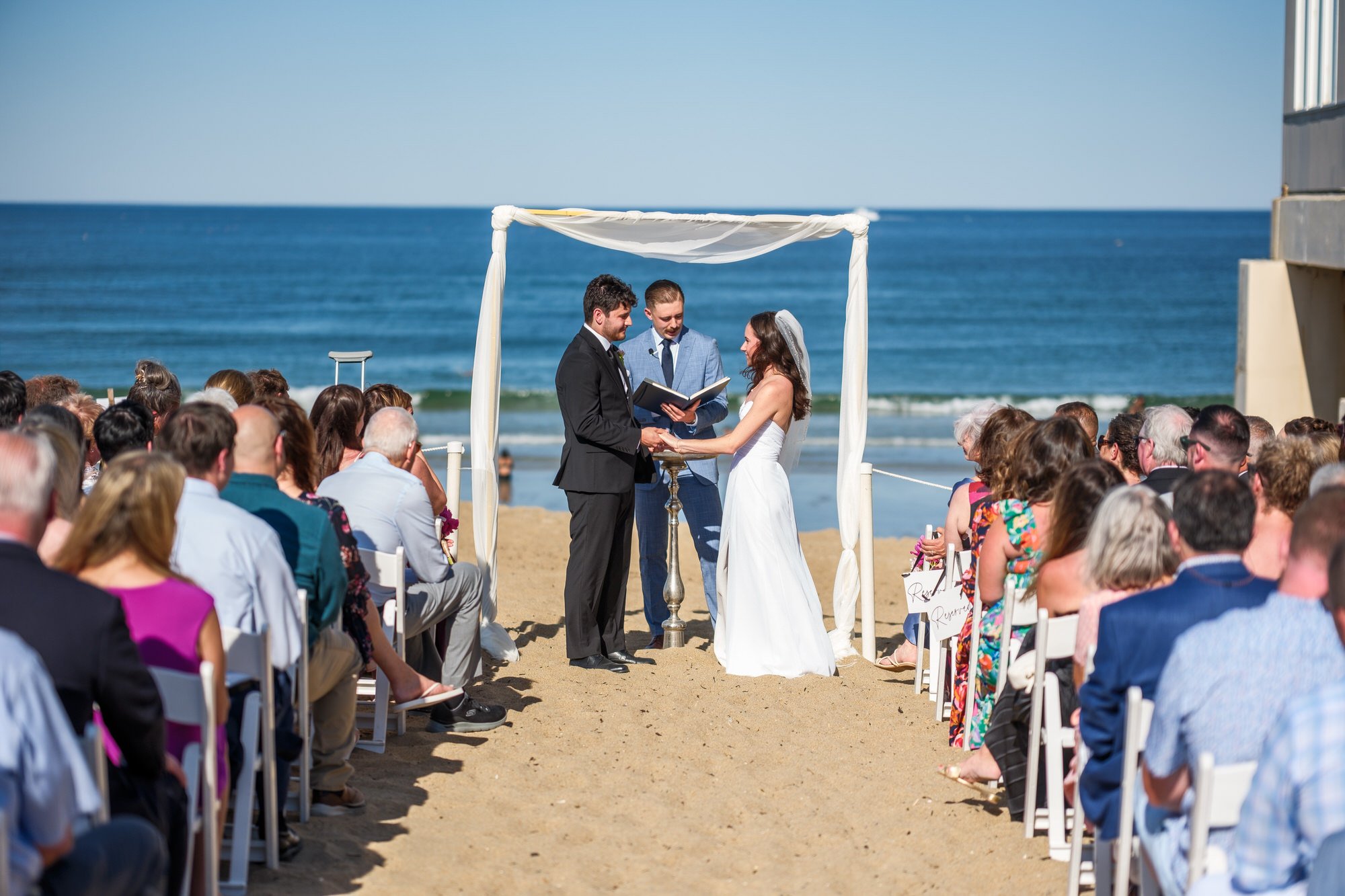 Oceanfront wedding ceremony under a white canopy at Blue Ocean Event Center in Salisbury, MA.