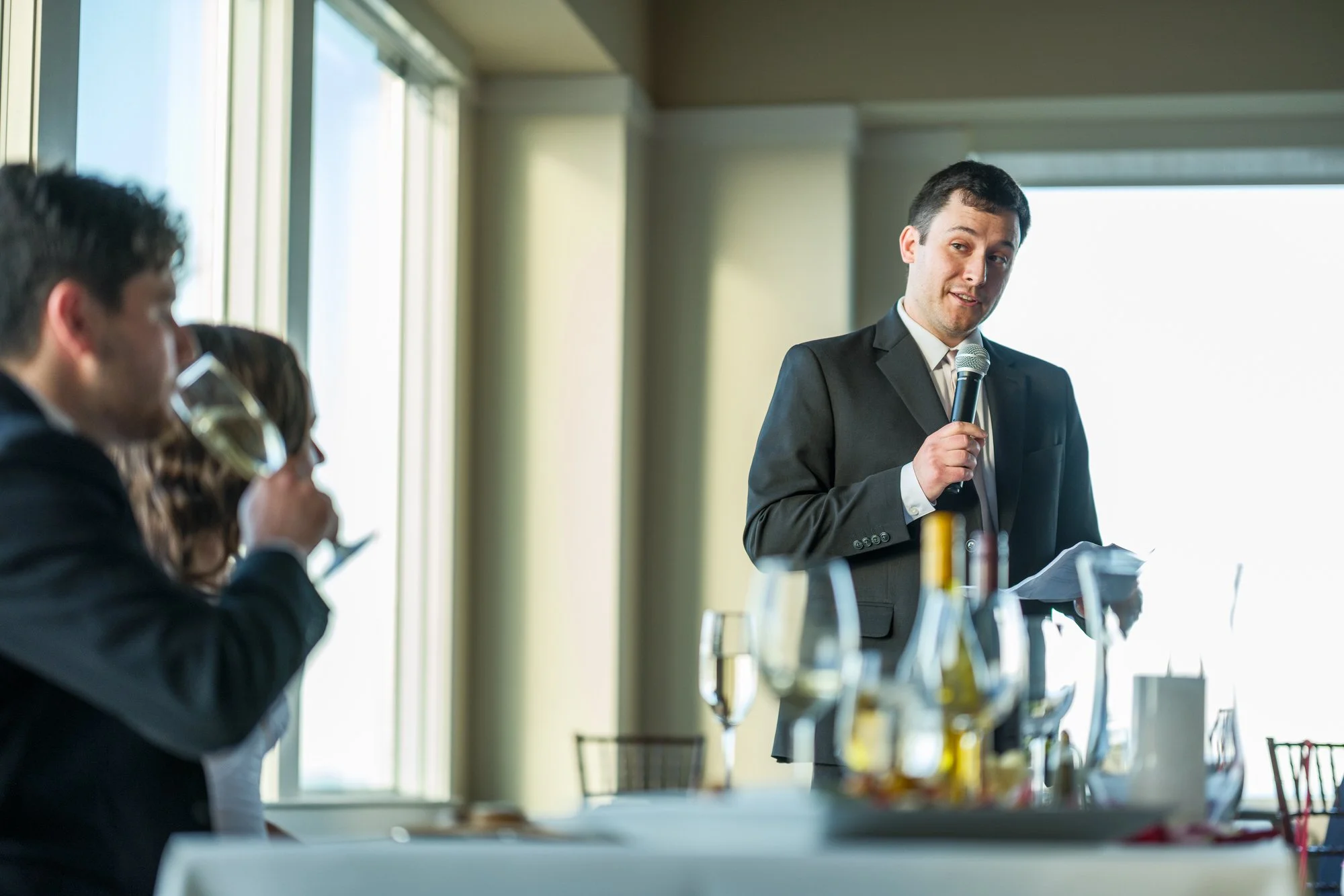Best man giving a reception speech beside the newlyweds at Blue Ocean Event Center.