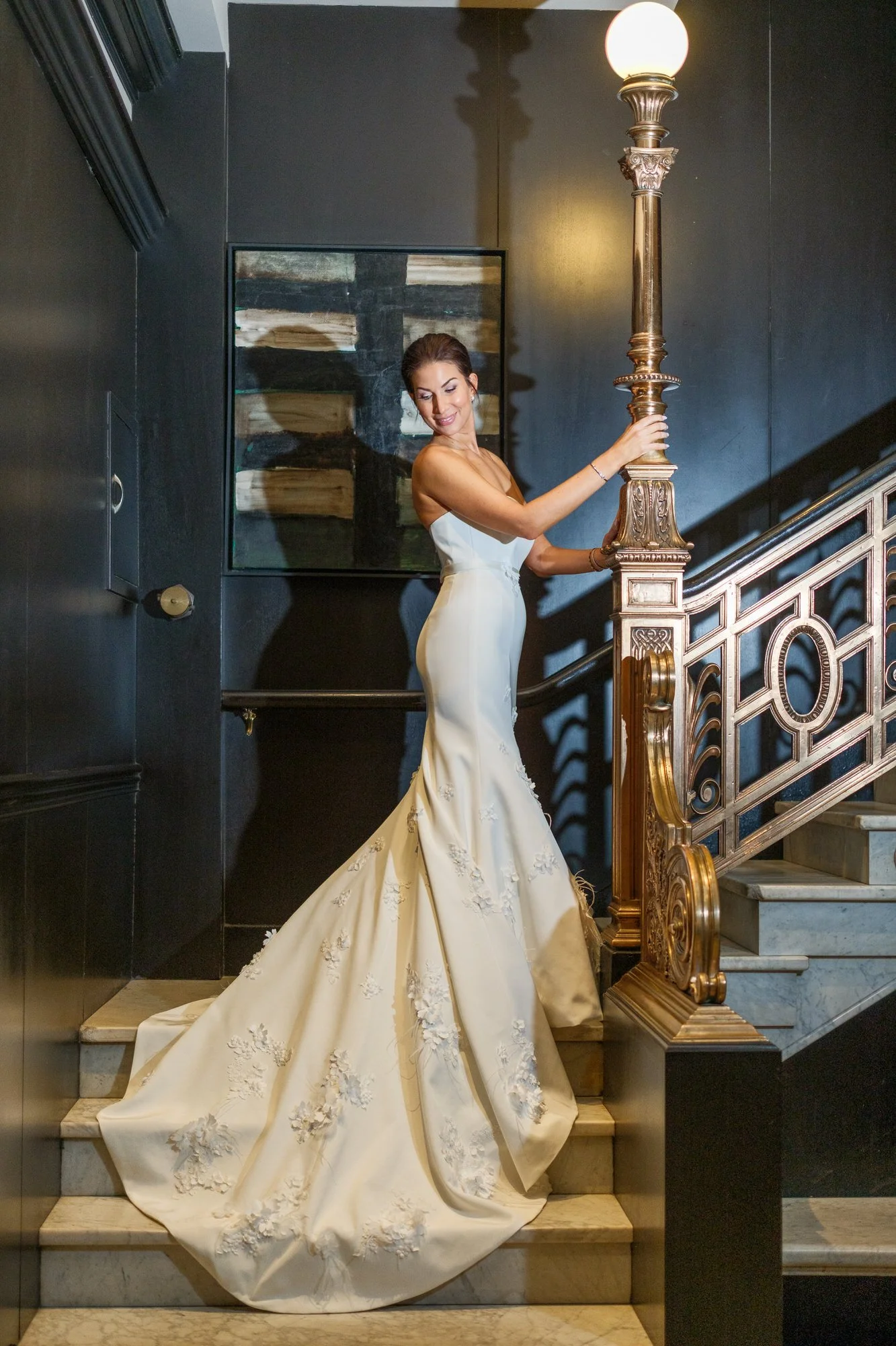 Bride in strapless mermaid gown posing on the ornate grand staircase inside the XV Beacon Hotel Boston