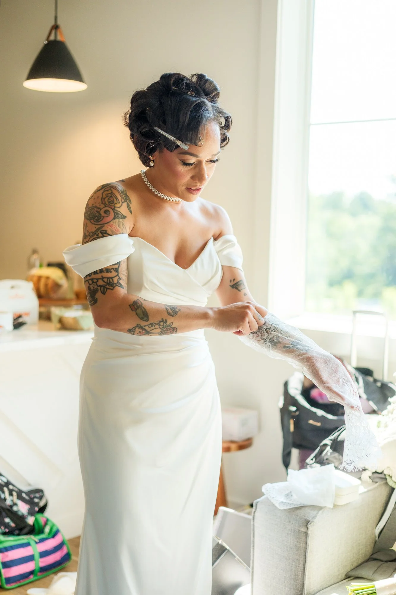 Bride in white gown preparing in the getting ready suite at Hyla Brook Estate