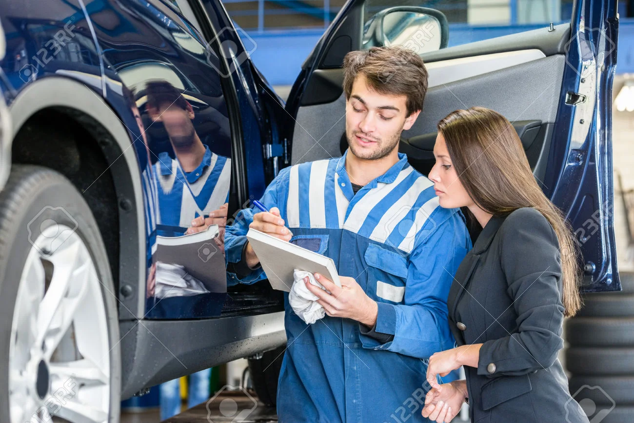 47728184-Car-mechanic-with-female-customer-going-through-maintenance-checklist-in-garage-Stock-Photo.jpg