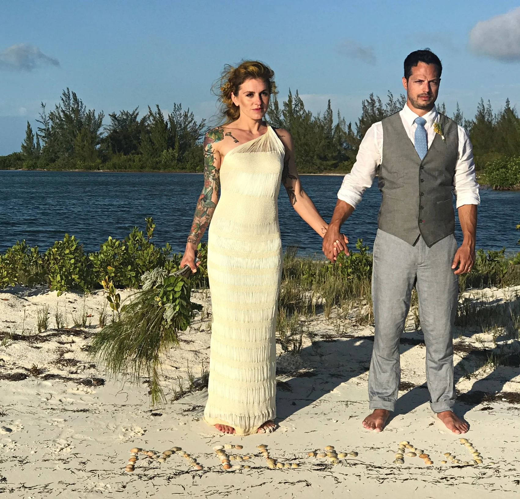 mel and her husband aj on their wedding day. mel is wearing her custom open back one shoulder gown