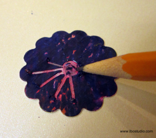 Using a dull pencil, scratch away the dark surface to let the colors below be seen.