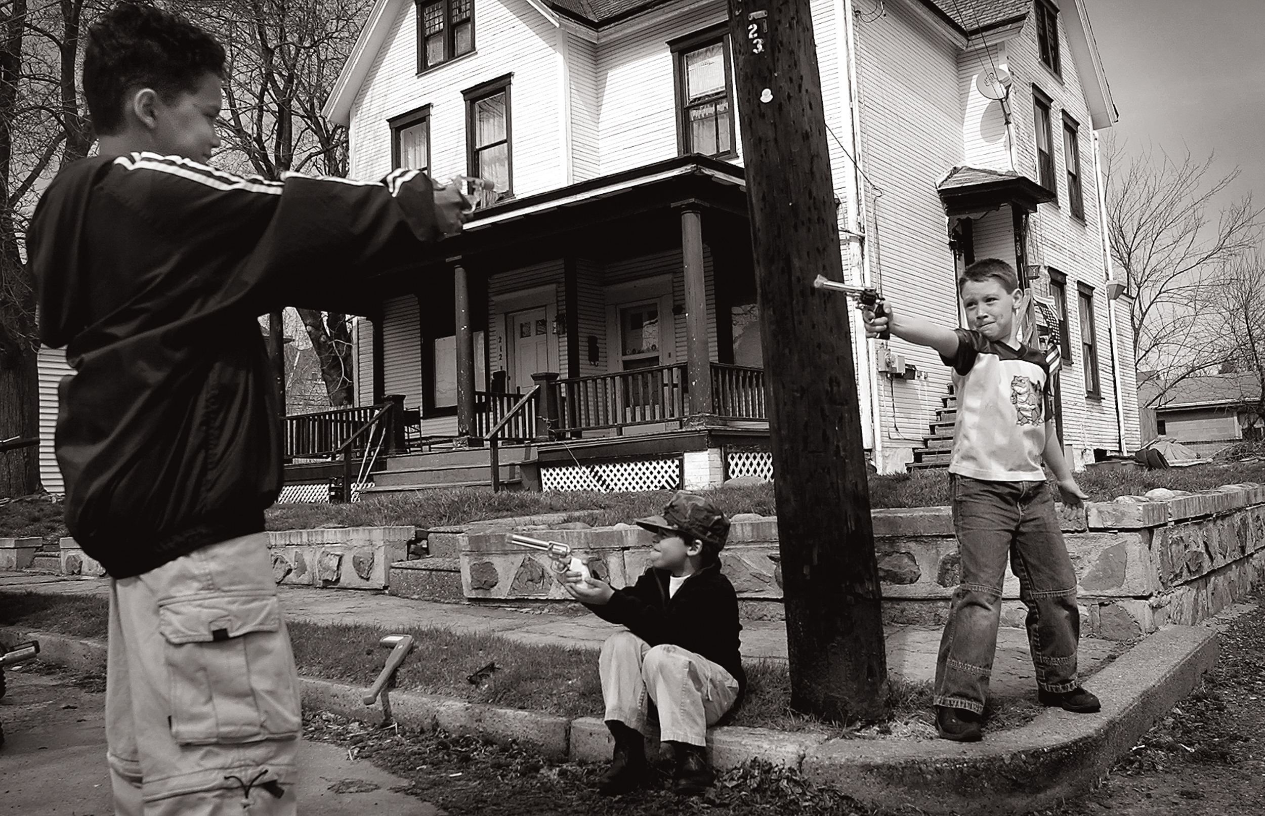 Boys play cops and robbers outside of a home in Tarentum, Pa.