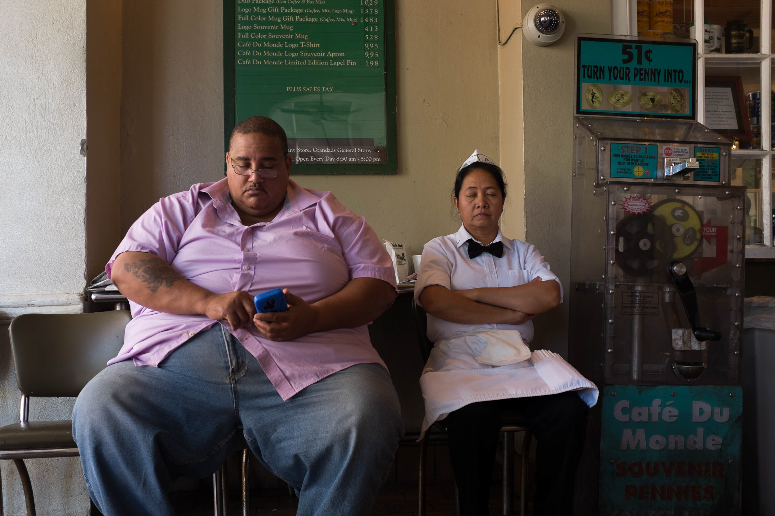 A man sits near a waitress at Café du Monde in New Orleans, La.