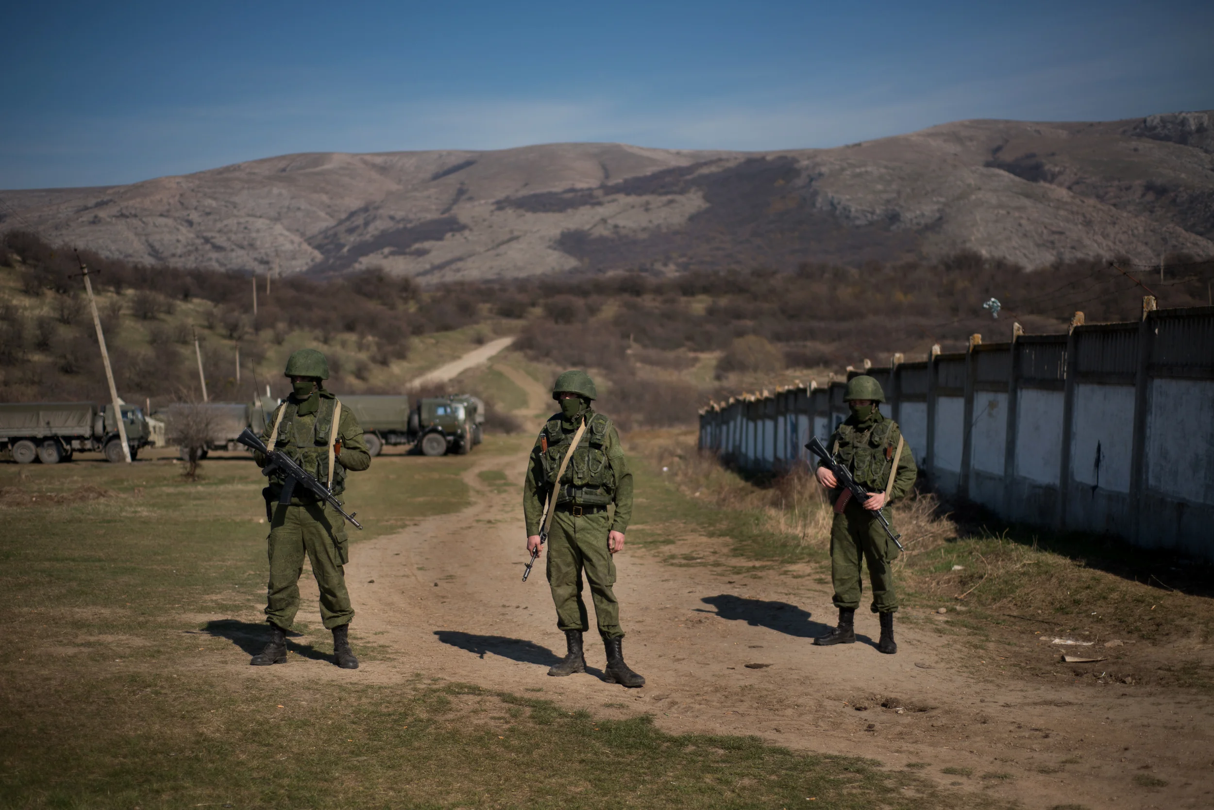 On the eve of the Crimean peninsula's referendum vote, armed men, believed to be a Russian serviceman, stand near a Ukrainian military base in Perevalnoye, near the Crimean city of Simferopol, on March 15, 2014.