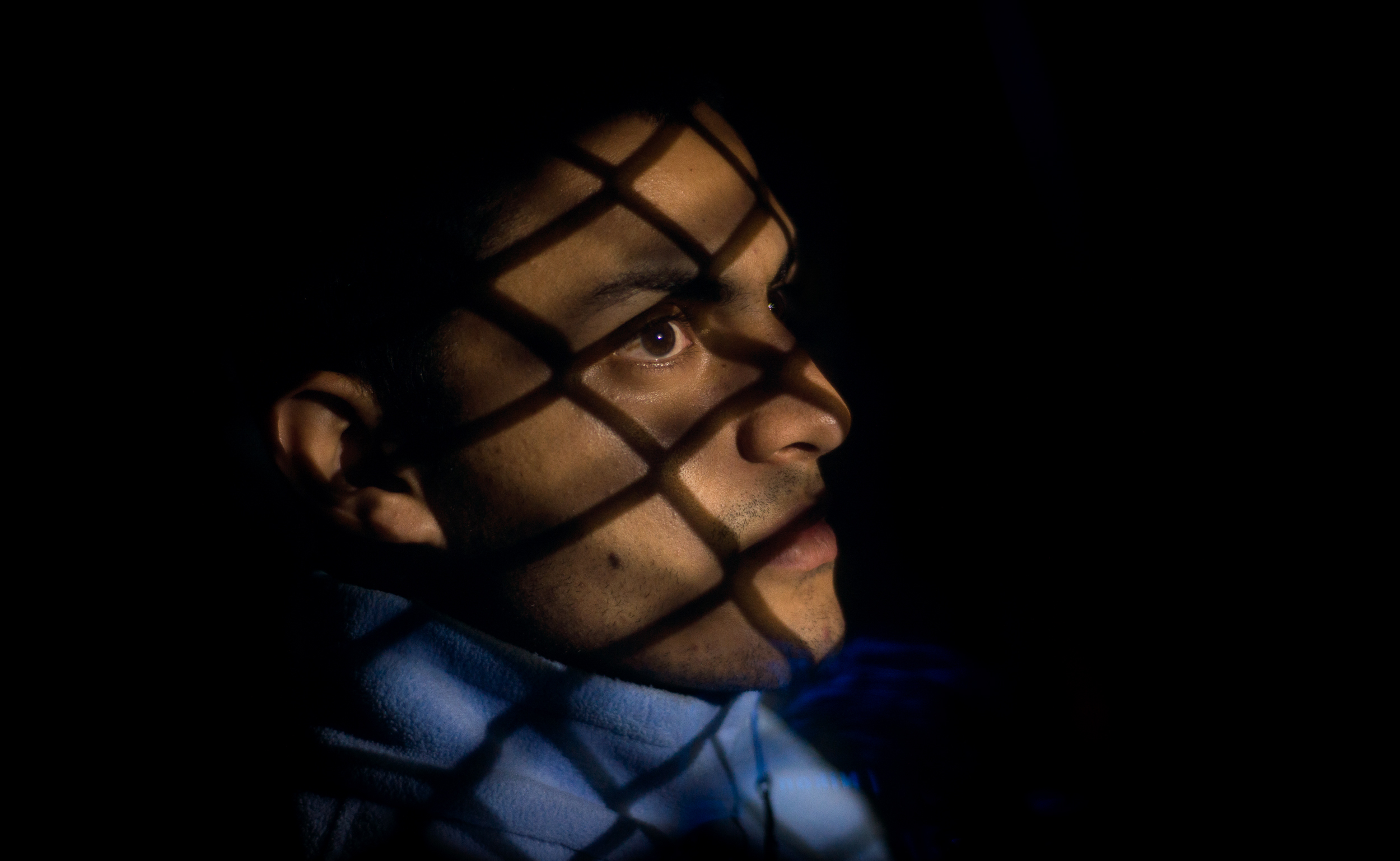 An undocumented immigrant from El Salvador sits in the back of a police cruiser after being apprehended while fleeing from police along Route 281 north of Edinburg, Texas.