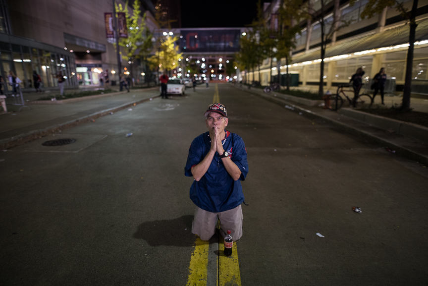 William Burgos of Cleveland prays in the street outside of Progressive Field during the 9th inning of game 7 of the World Series between the Cleveland Indians and the Chicago Cubs on November 2, 2016 in Cleveland, Ohio. 