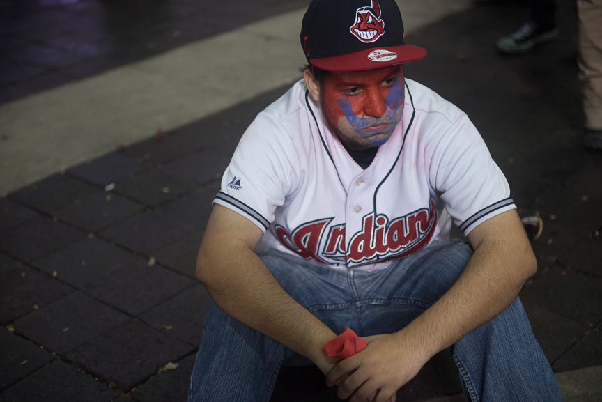 An Indian fan sits in the street after the Chicago Cubs defeated the Cleveland Indians 8-7 in game 7 of the World Series on November 3, 2016 in Cleveland, Ohio. 