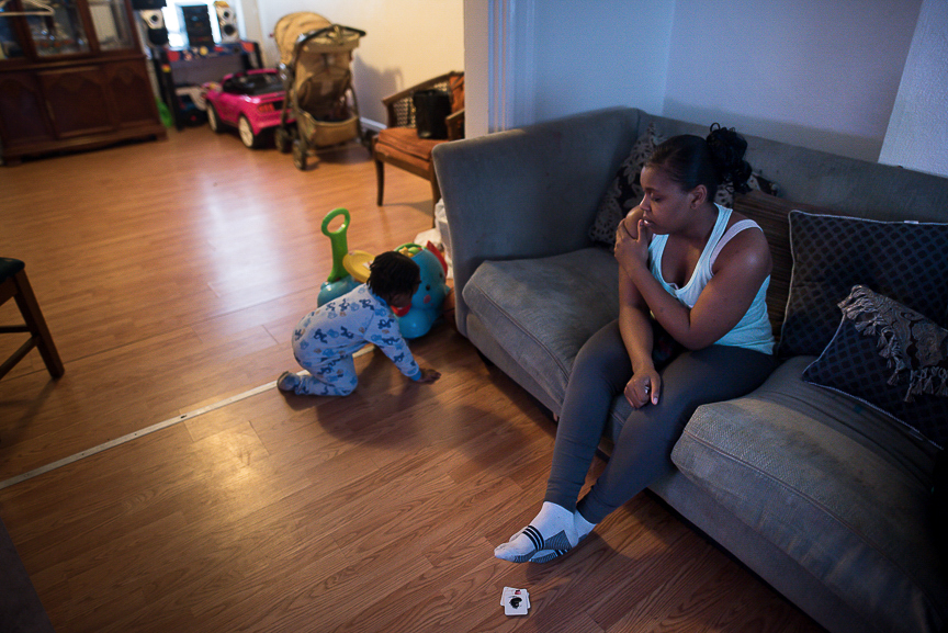 Dezmaire Baker sits on the couch watching her 2-year-old son, Dorian, play at her family's Braddock home. Dezmaire gave birth to Dorian when she was in eighth grade.